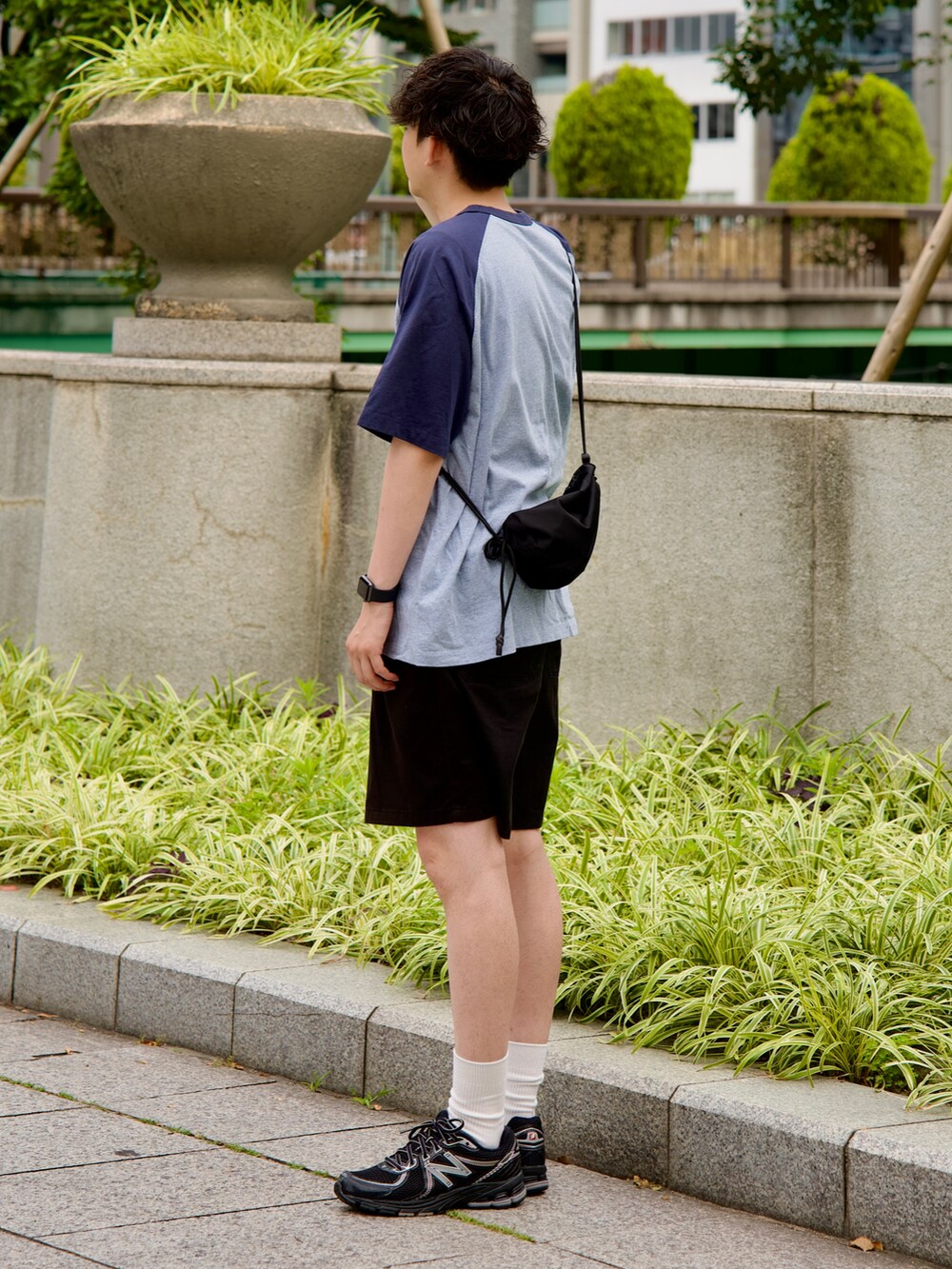 ブルー系のTシャツ/カットソー、ブラック系のパンツ、ブラック系のスニーカーを着用したメンズの夏コーディネートの2枚目の写真