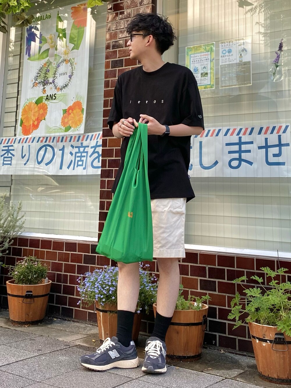 ブラック系のTシャツ/カットソー、ホワイト系のパンツ、ブルー系のスニーカーを着用したメンズの夏コーディネートの3枚目の写真