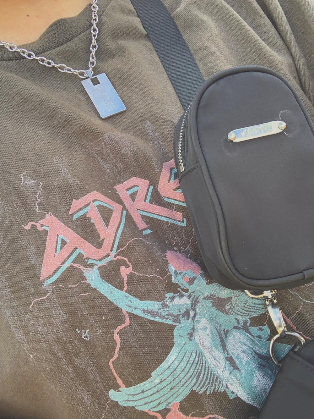 グレー系のTシャツ/カットソー、ブラック系のショルダーバッグ、ブラック系のデニムパンツを着用したメンズの秋コーディネートの3枚目の写真