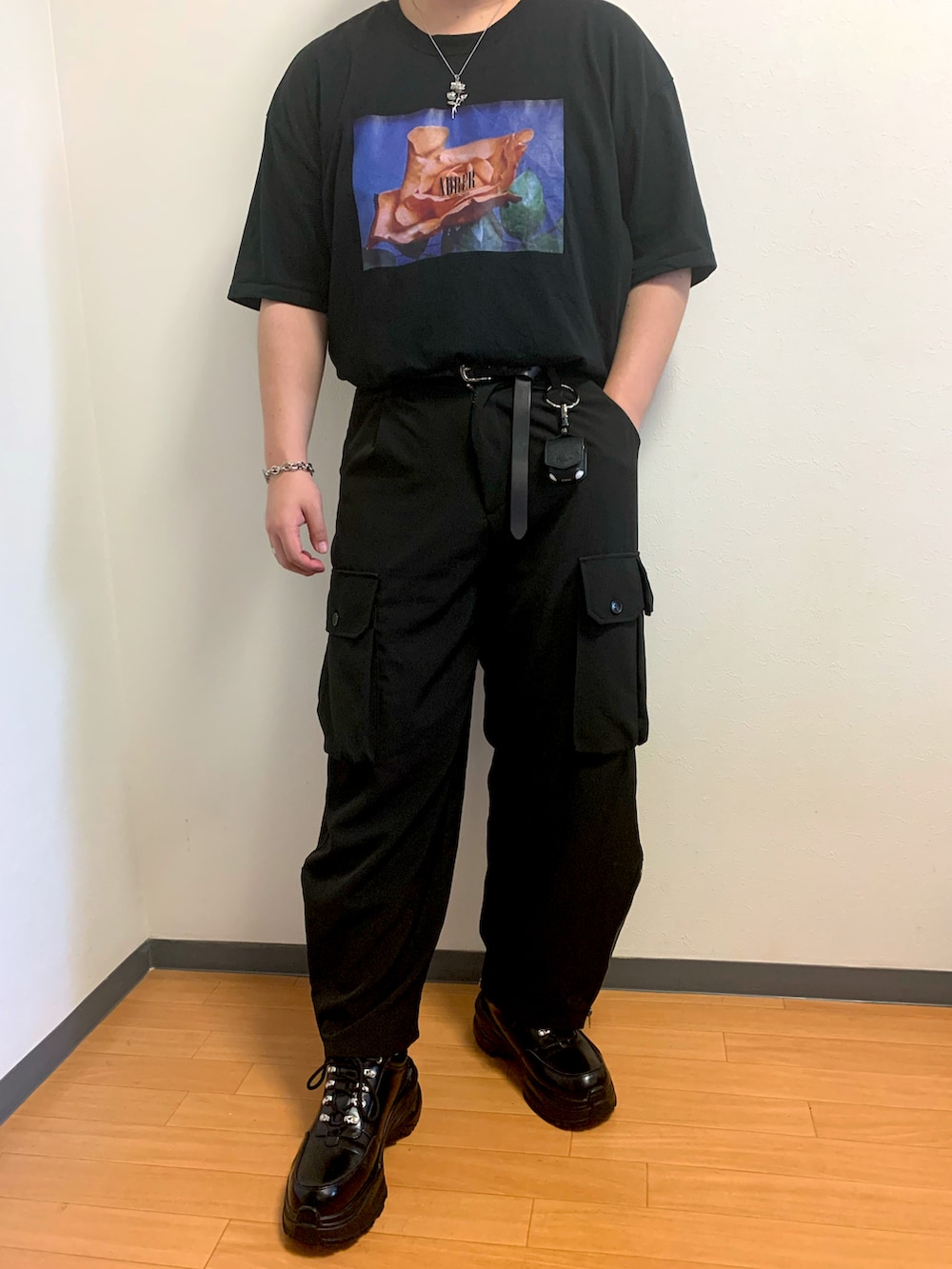 ブラック系のカーゴパンツ、ブラック系のスニーカー、ブラック系のTシャツ/カットソーを着用したメンズの秋コーディネートの2枚目の写真