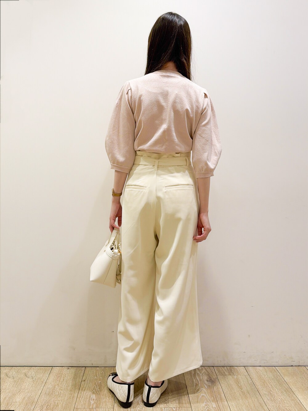 ピンク系のニット/セーター、ホワイト系のその他パンツ、ホワイト系のショルダーバッグを着用したレディースの春コーディネートの5枚目の写真