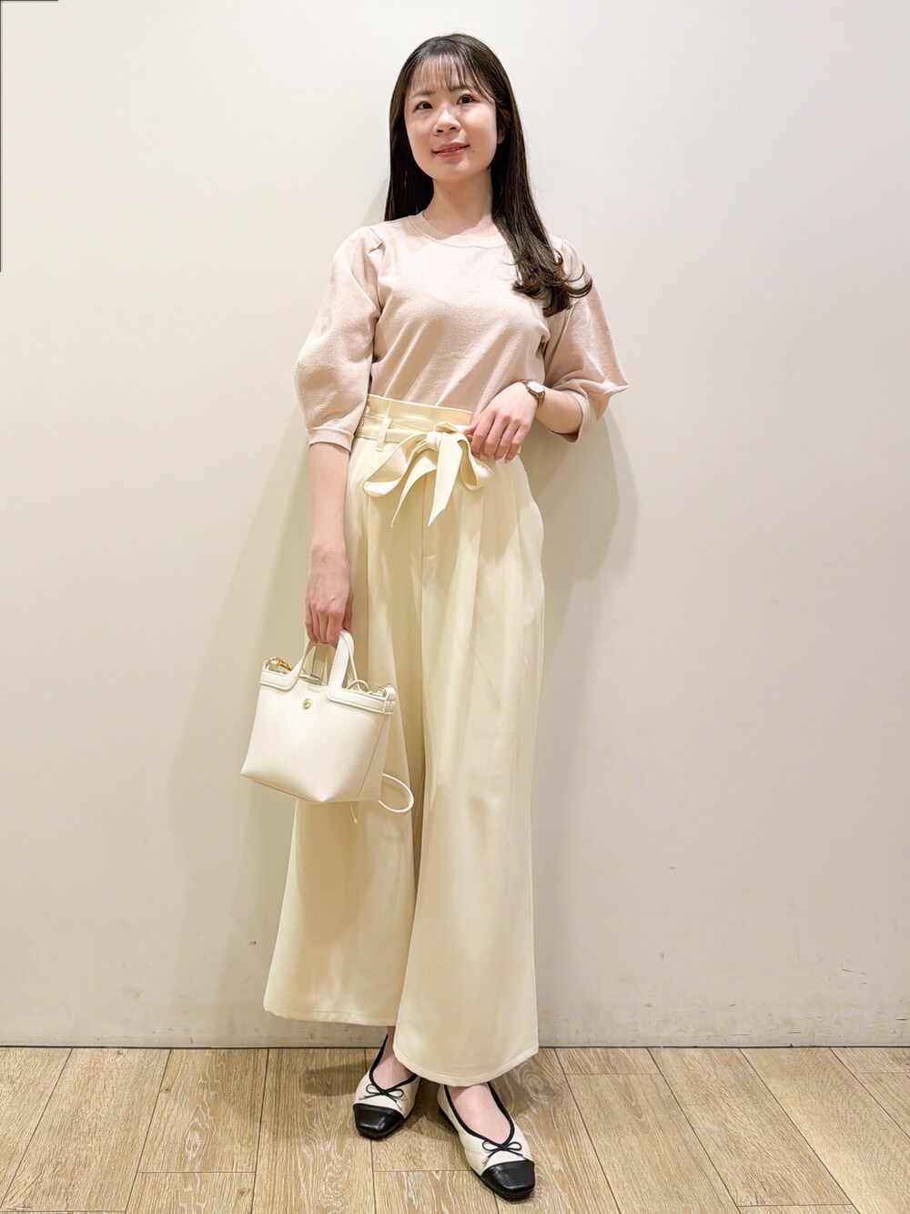 ピンク系のニット/セーター、ホワイト系のその他パンツ、ホワイト系のショルダーバッグを着用したレディースの春コーディネートの3枚目の写真