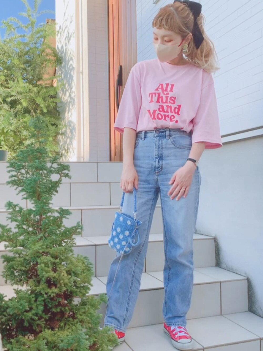 レッド系のスニーカー、ブルー系のデニムパンツ、ブルー系のショルダーバッグを着用したレディースの夏コーディネートの2枚目の写真