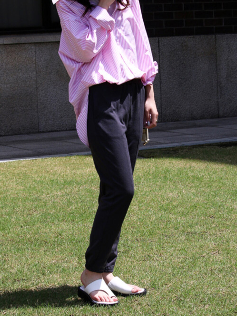 グレー系のスウェットパンツ、ホワイト系のサンダル、ピンク系のシャツ/ブラウスを着用したレディースの夏コーディネートの3枚目の写真