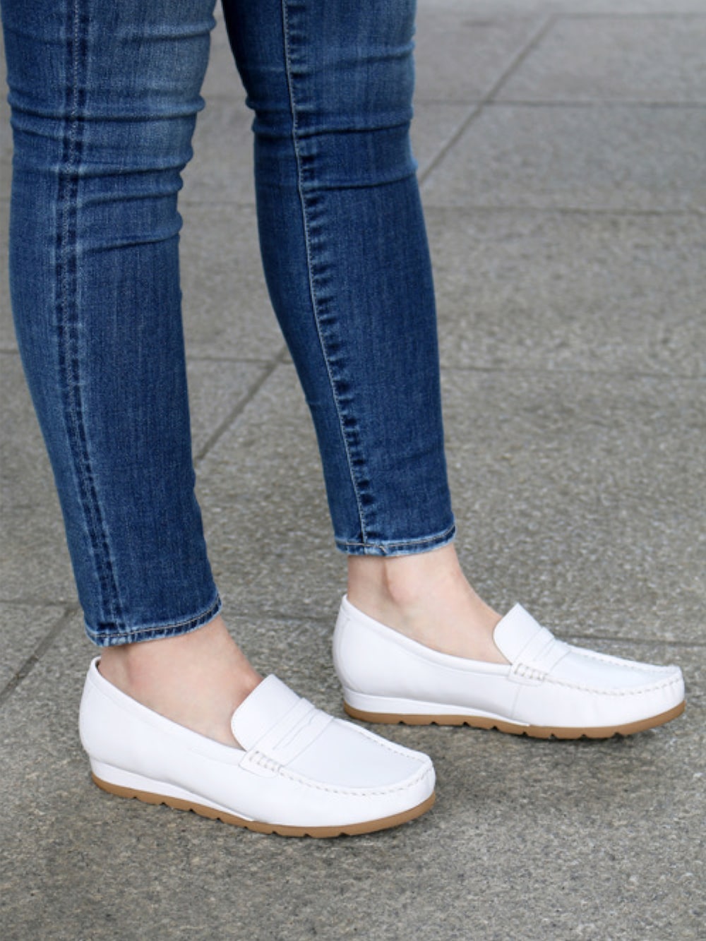 ホワイト系のショルダーバッグ、ホワイト系のローファー、ブルー系のデニムパンツを着用したレディースの夏コーディネートの4枚目の写真