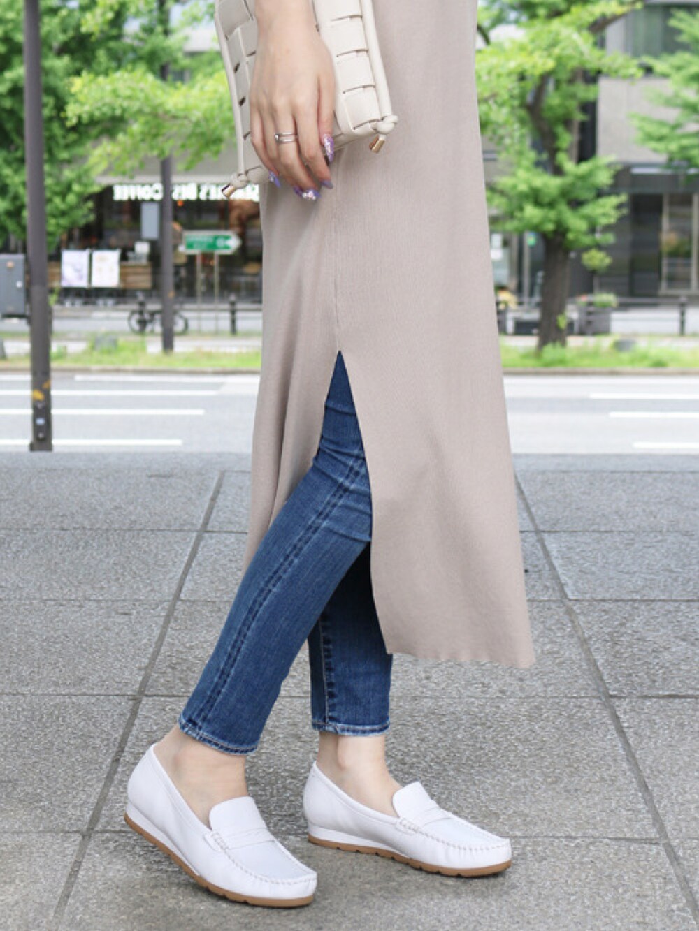 ホワイト系のショルダーバッグ、ホワイト系のローファー、ブルー系のデニムパンツを着用したレディースの夏コーディネートの3枚目の写真