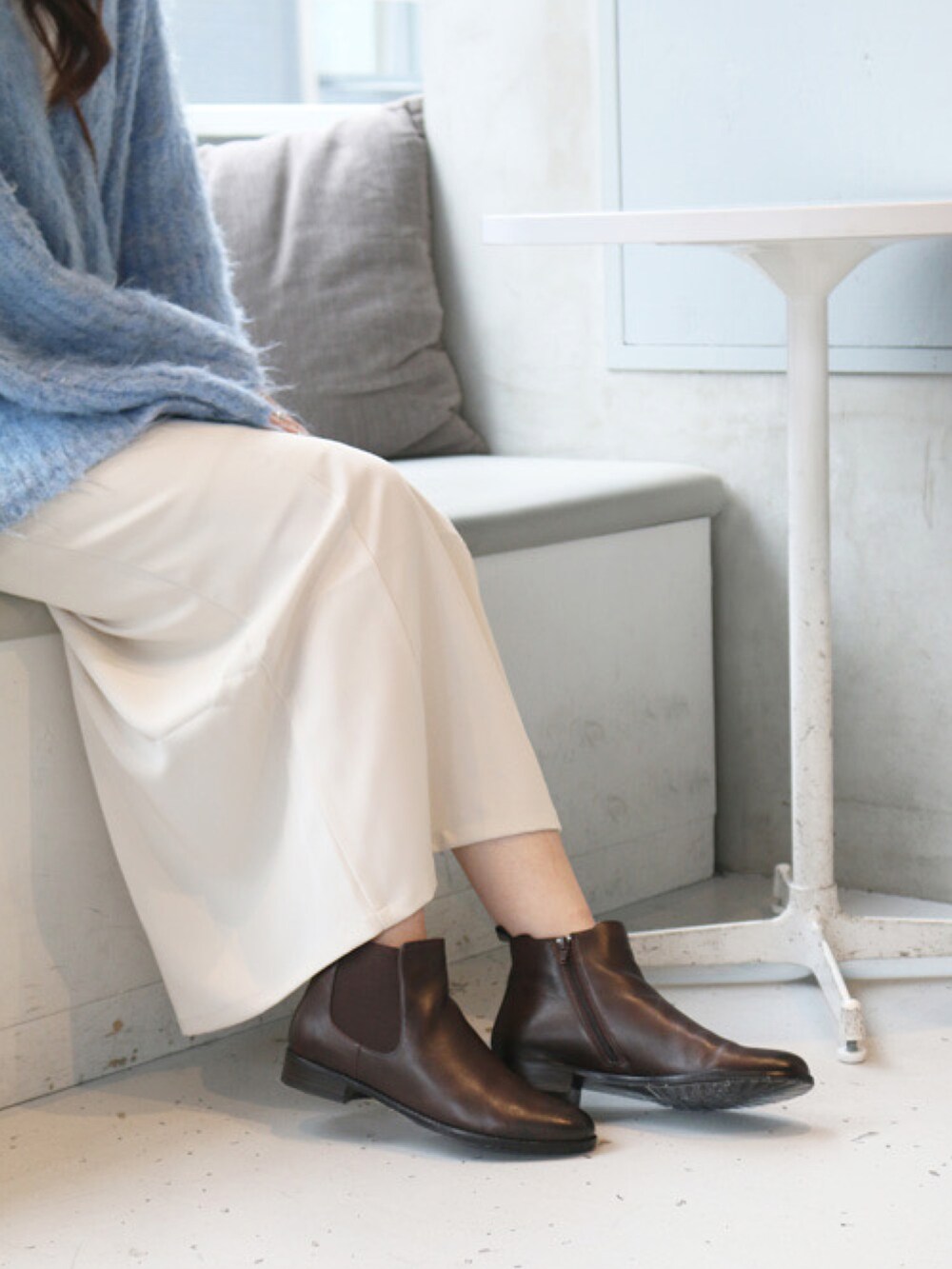 ブルー系のカーディガン/ボレロ、ブラウン系のブーツを着用したレディースの秋コーディネートの3枚目の写真