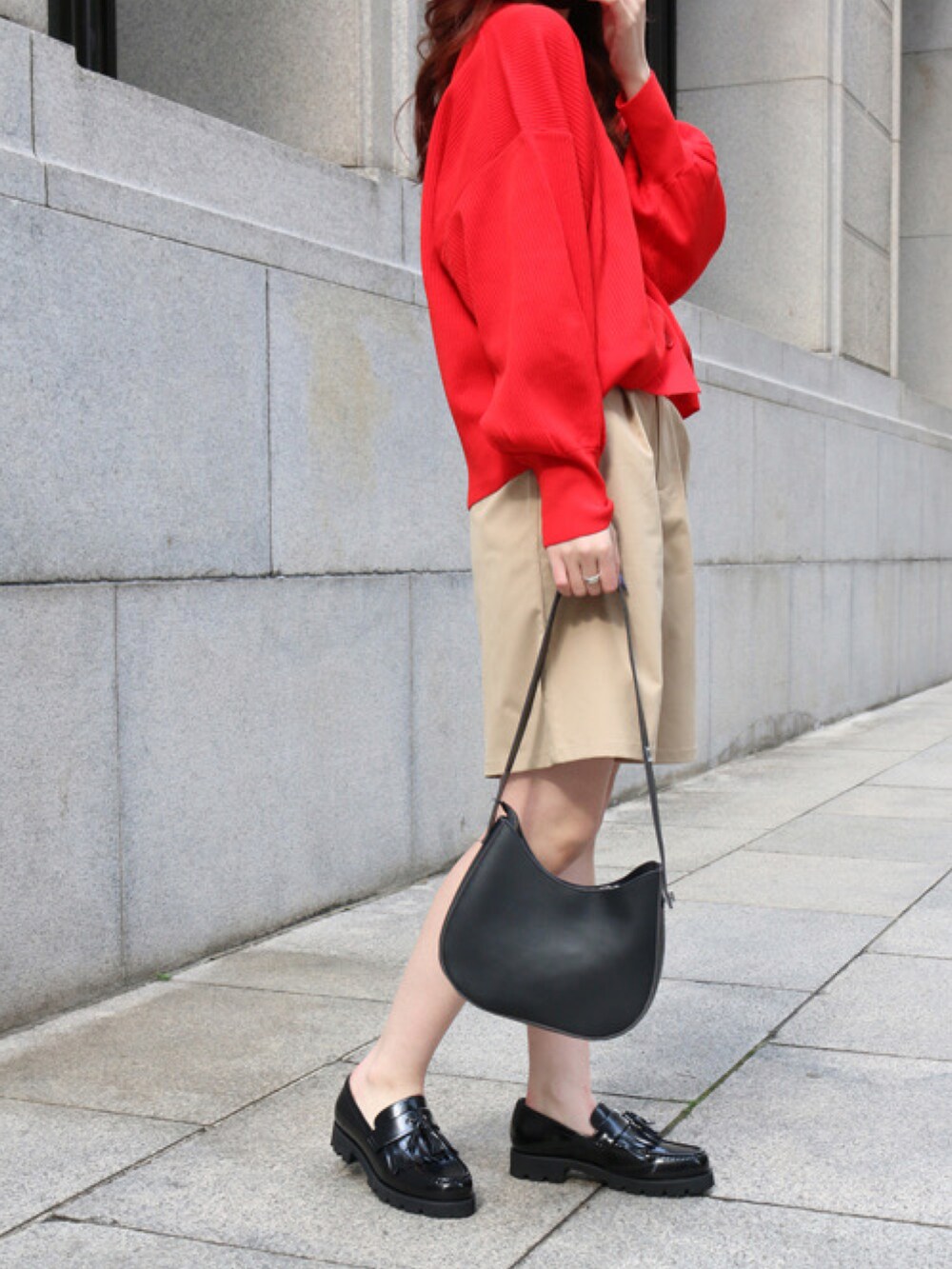 レッド系のカーディガン/ボレロ、ベージュ系のチノパンツ、ブラック系のローファーを着用したレディースの春コーディネートの2枚目の写真