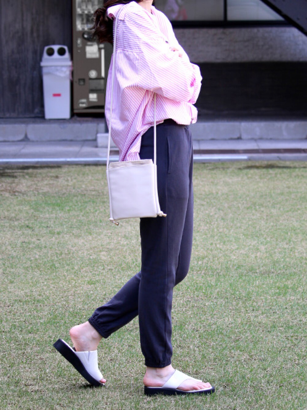 グレー系のスウェットパンツ、ホワイト系のサンダル、ピンク系のシャツ/ブラウスを着用したレディースの夏コーディネートの2枚目の写真