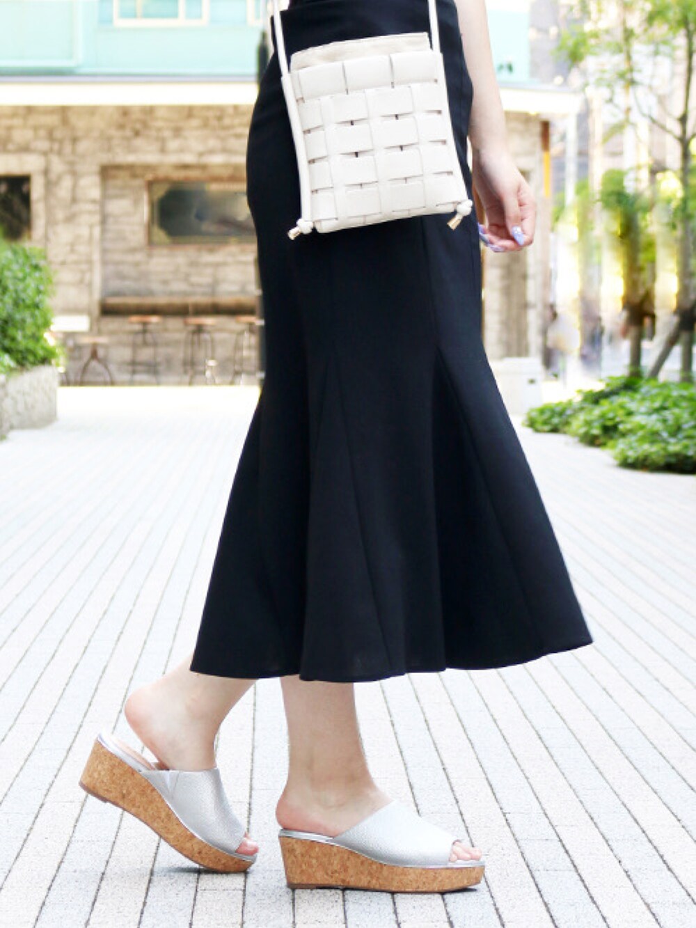 シルバー系のサンダル、ブラック系のスカート、ホワイト系のTシャツ/カットソーを着用したレディースの夏コーディネートの2枚目の写真