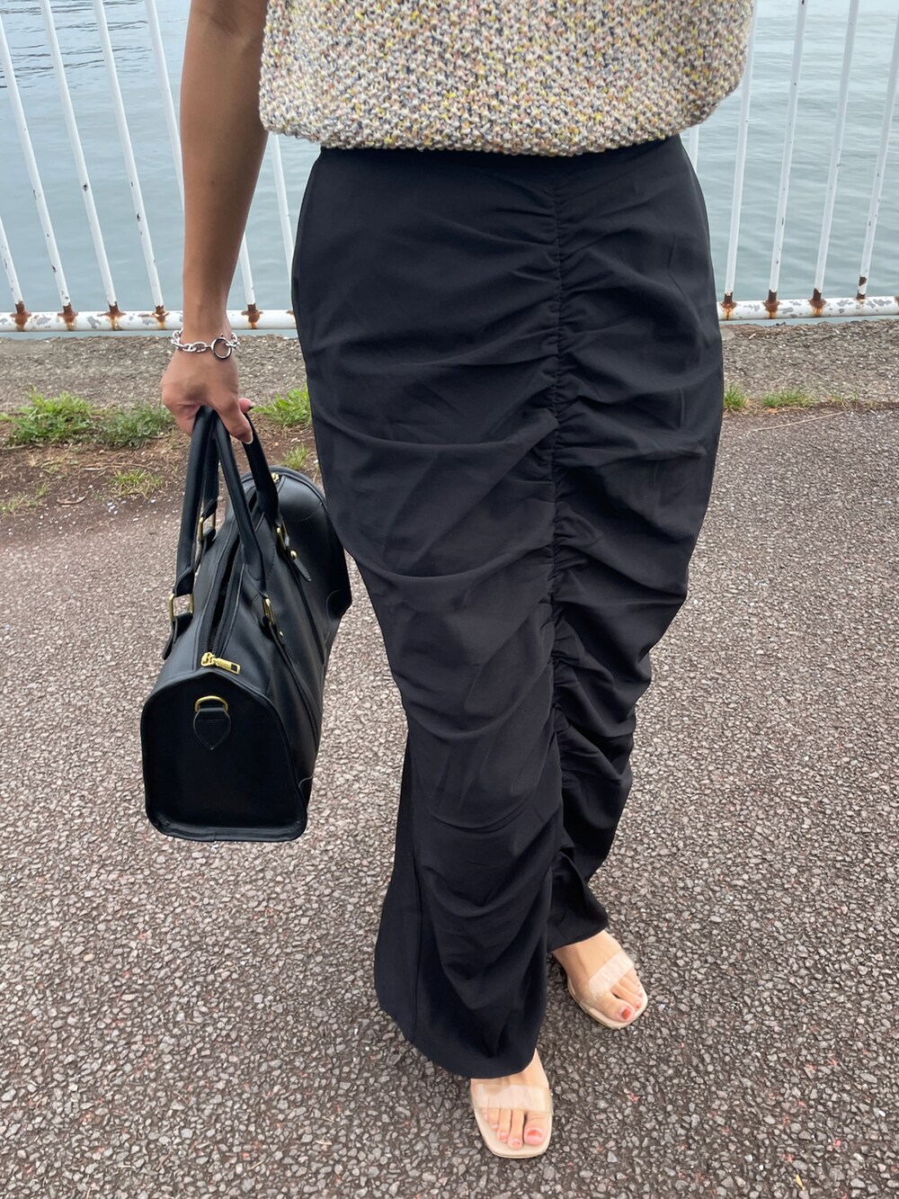 ベージュ系のベスト、ピンク系のTシャツ/カットソー、ブラック系のスカートを着用したレディースの秋コーディネートの2枚目の写真