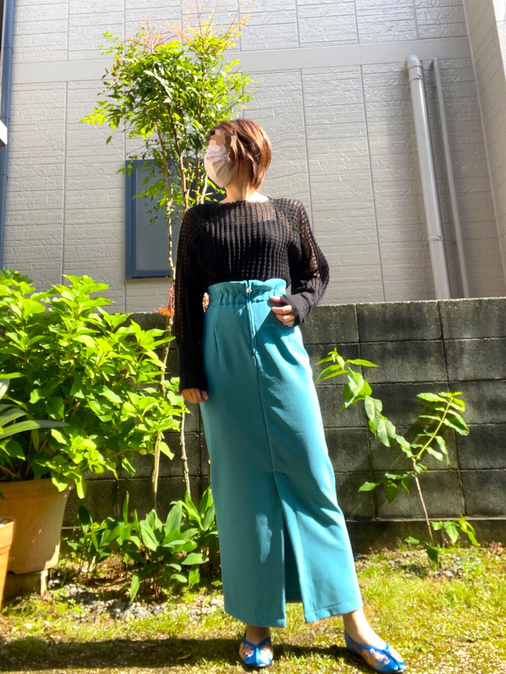 グリーン系のベスト、ブルー系のスカート、ブルー系のシューズを着用したレディースの春コーディネートの3枚目の写真