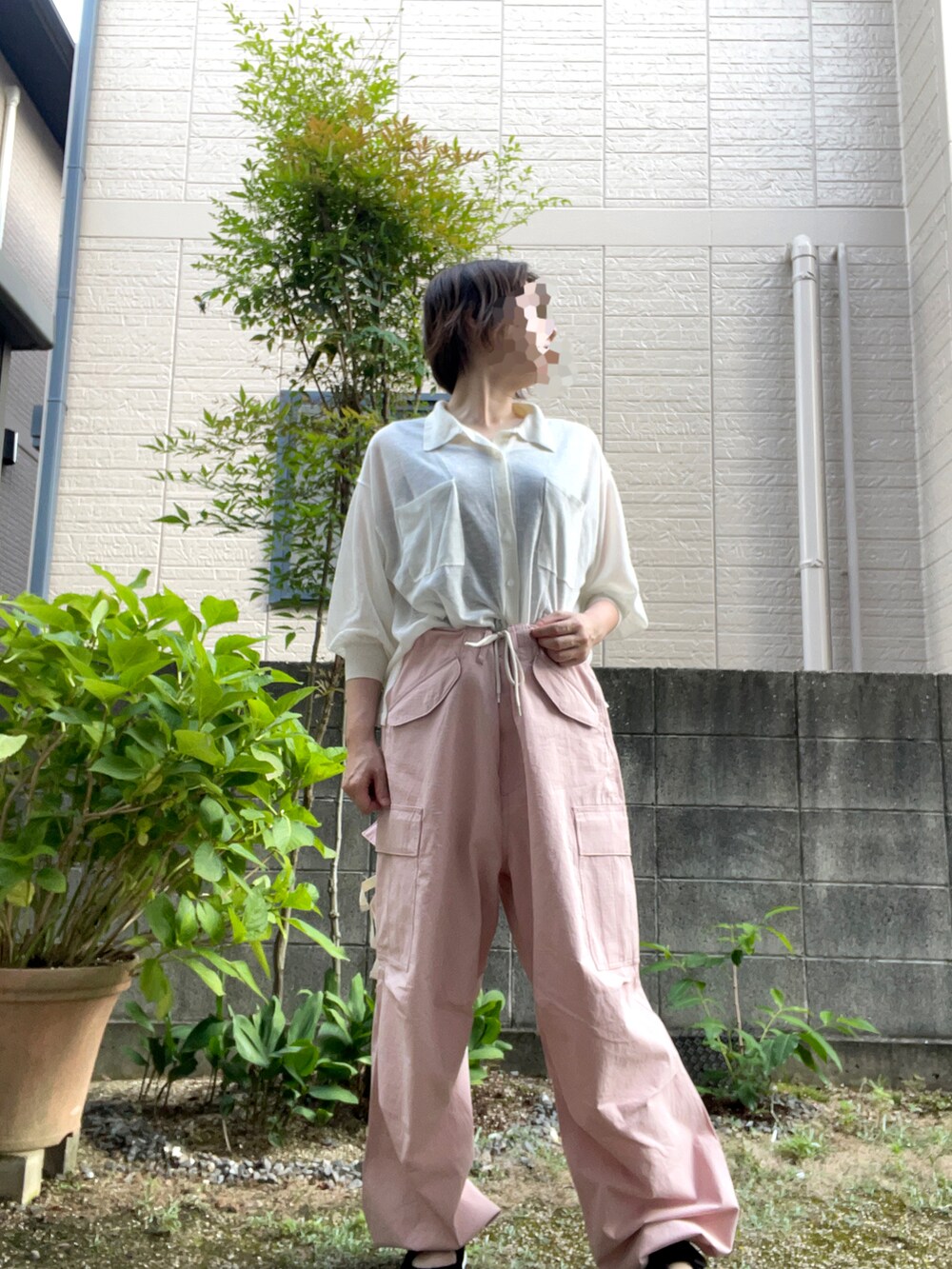 ピンク系のその他パンツ、ホワイト系のニット/セーター、ブラック系のサンダルを着用したレディースの夏コーディネートの3枚目の写真