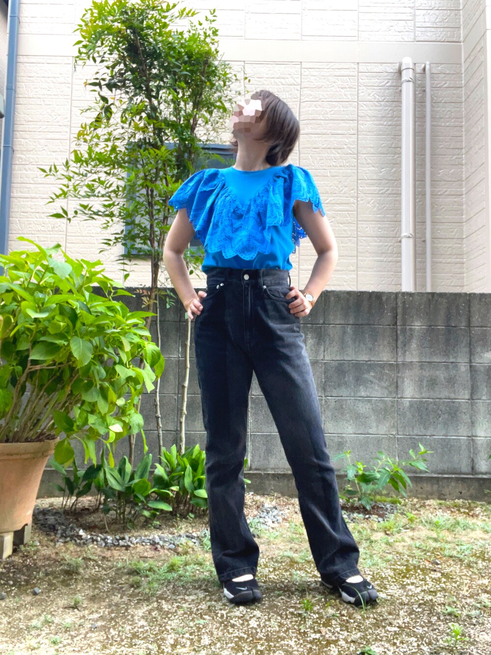 ブラック系のデニムパンツ、ブルー系のTシャツ/カットソー、ブラック系のサンダルを着用したレディースの夏コーディネートの2枚目の写真