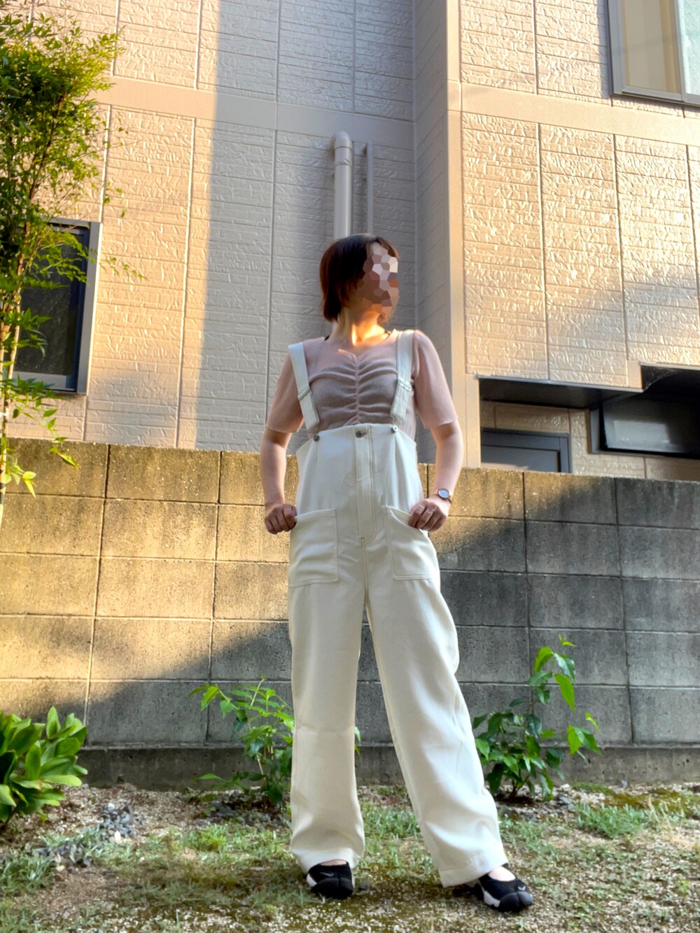 ホワイト系のサロペット/オーバーオール、ピンク系のTシャツ/カットソー、ブラック系のサンダルを着用したレディースの夏コーディネートの2枚目の写真