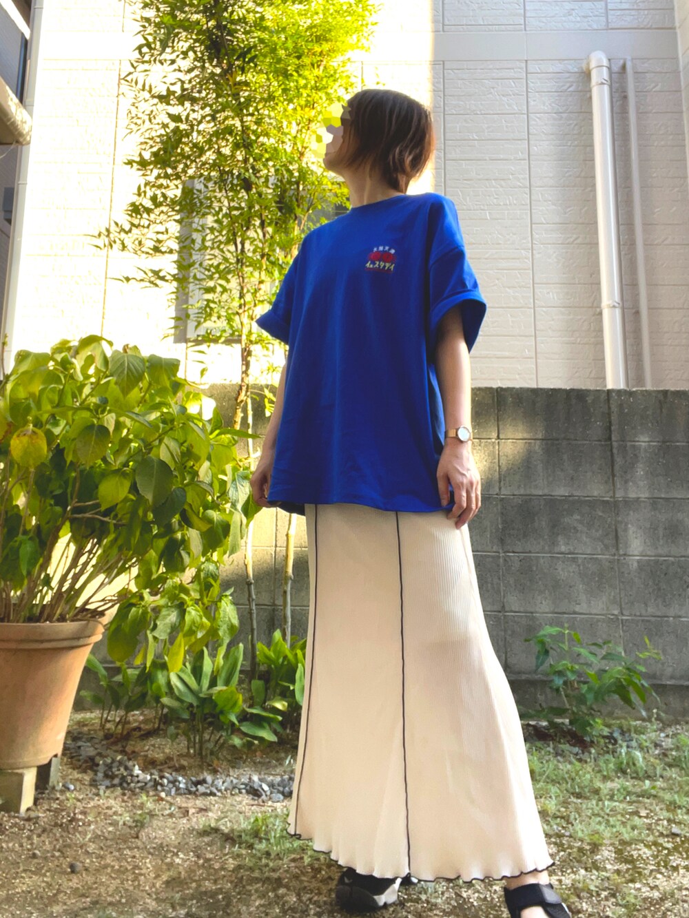 ホワイト系のスカート、ブルー系のTシャツ/カットソー、ブラック系のサンダルを着用したレディースの夏コーディネートの2枚目の写真