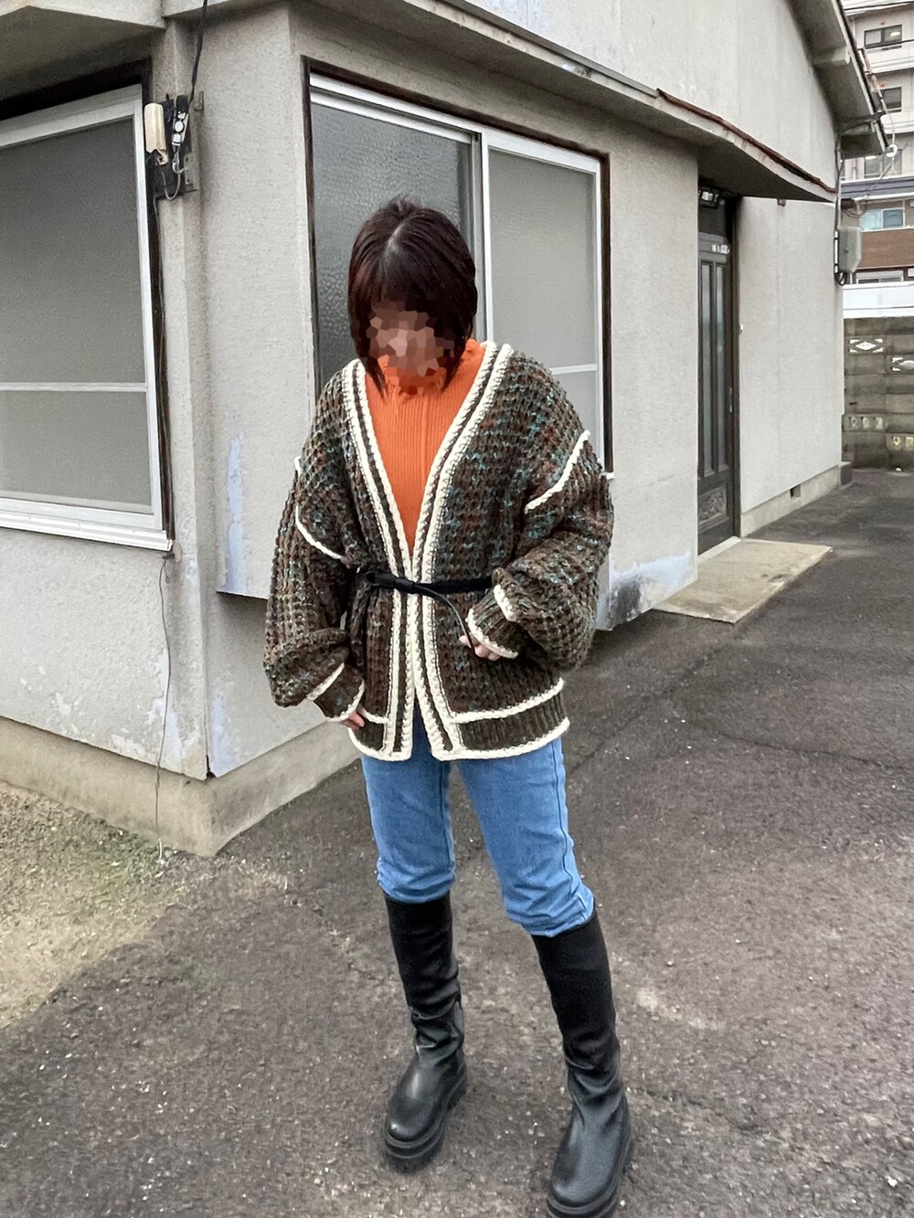 ブラウン系のカーディガン/ボレロ、ブルー系のデニムパンツ、ブラック系のブーツを着用したレディースの冬コーディネートの3枚目の写真