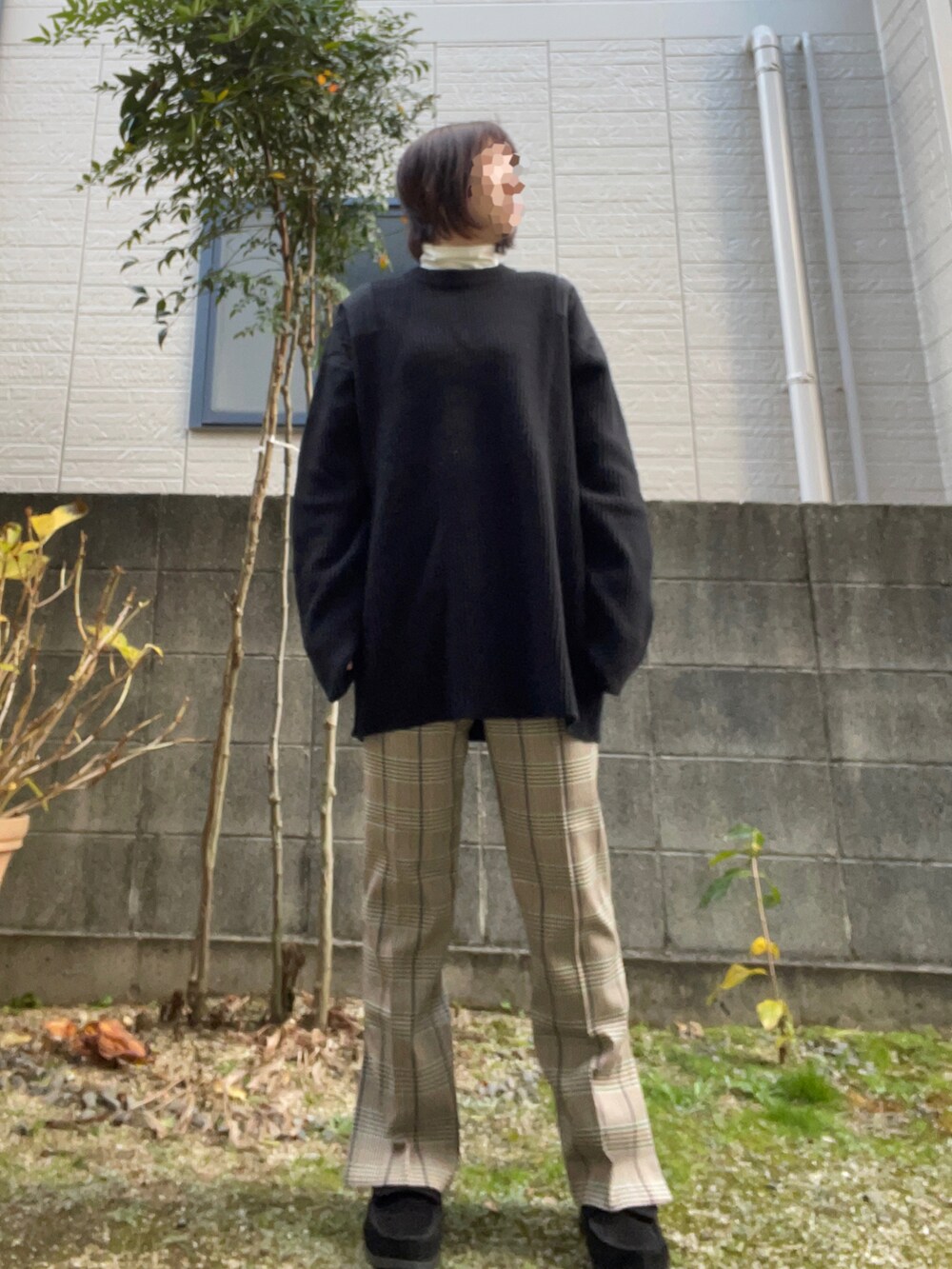 ブラック系のニット/セーター、ベージュ系のパンツ、ブラック系のスニーカーを着用したレディースの冬コーディネートの3枚目の写真