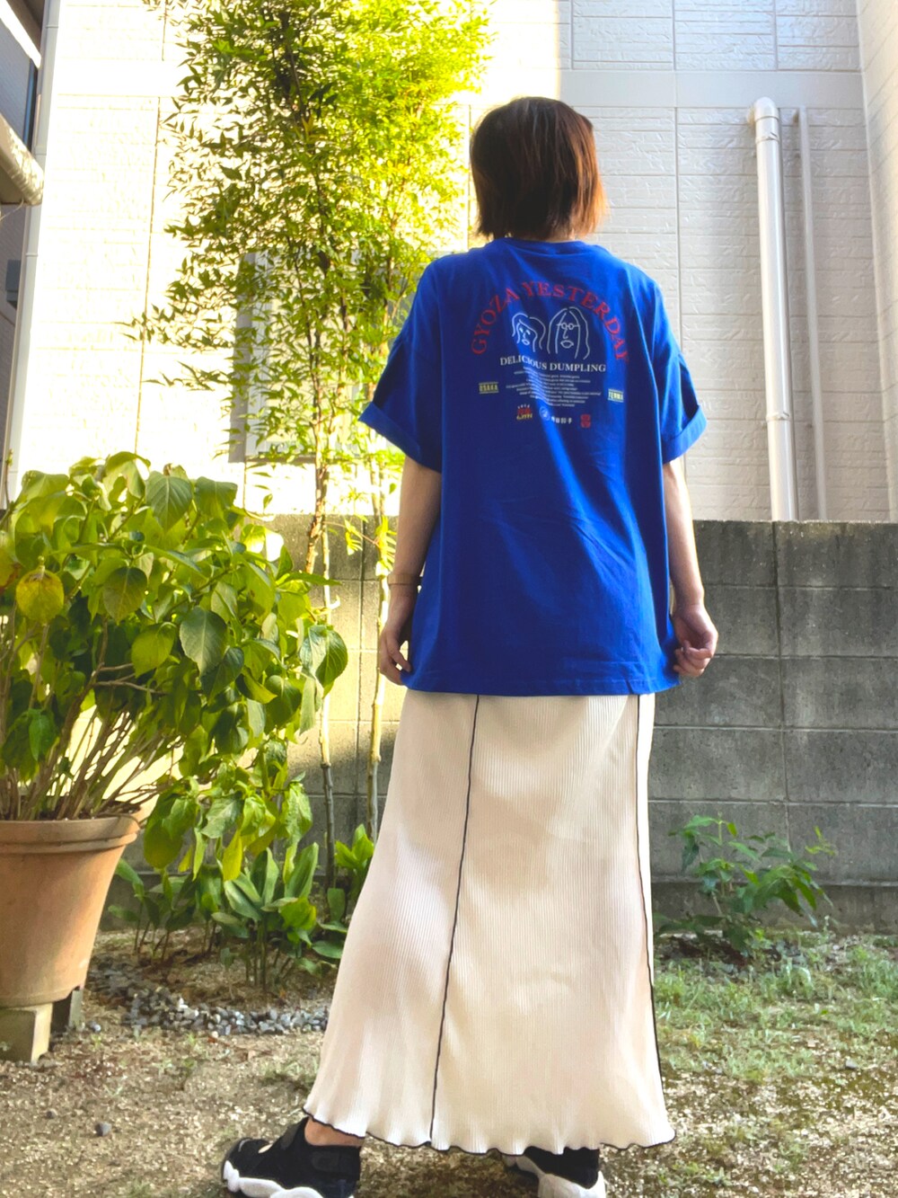 ホワイト系のスカート、ブルー系のTシャツ/カットソー、ブラック系のサンダルを着用したレディースの夏コーディネートの4枚目の写真