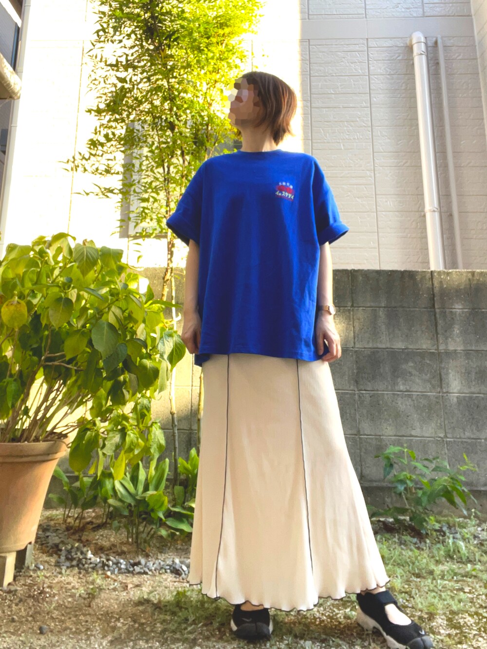 ホワイト系のスカート、ブルー系のTシャツ/カットソー、ブラック系のサンダルを着用したレディースの夏コーディネートの3枚目の写真