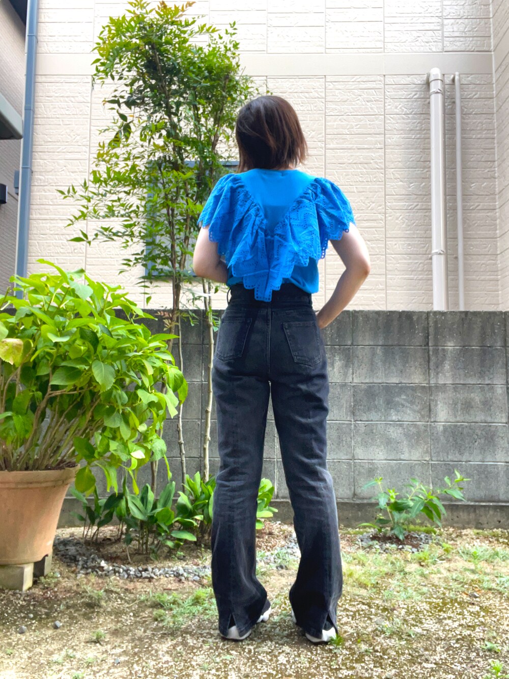 ブラック系のデニムパンツ、ブルー系のTシャツ/カットソー、ブラック系のサンダルを着用したレディースの夏コーディネートの3枚目の写真