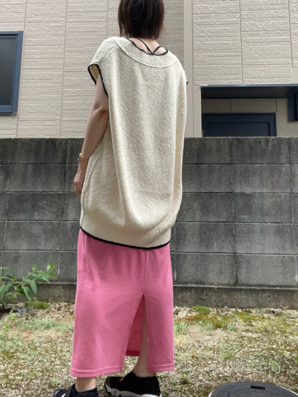 ホワイト系のベスト、ブラック系のサンダル、ブラック系のキャミソールを着用したレディースの夏コーディネートの4枚目の写真