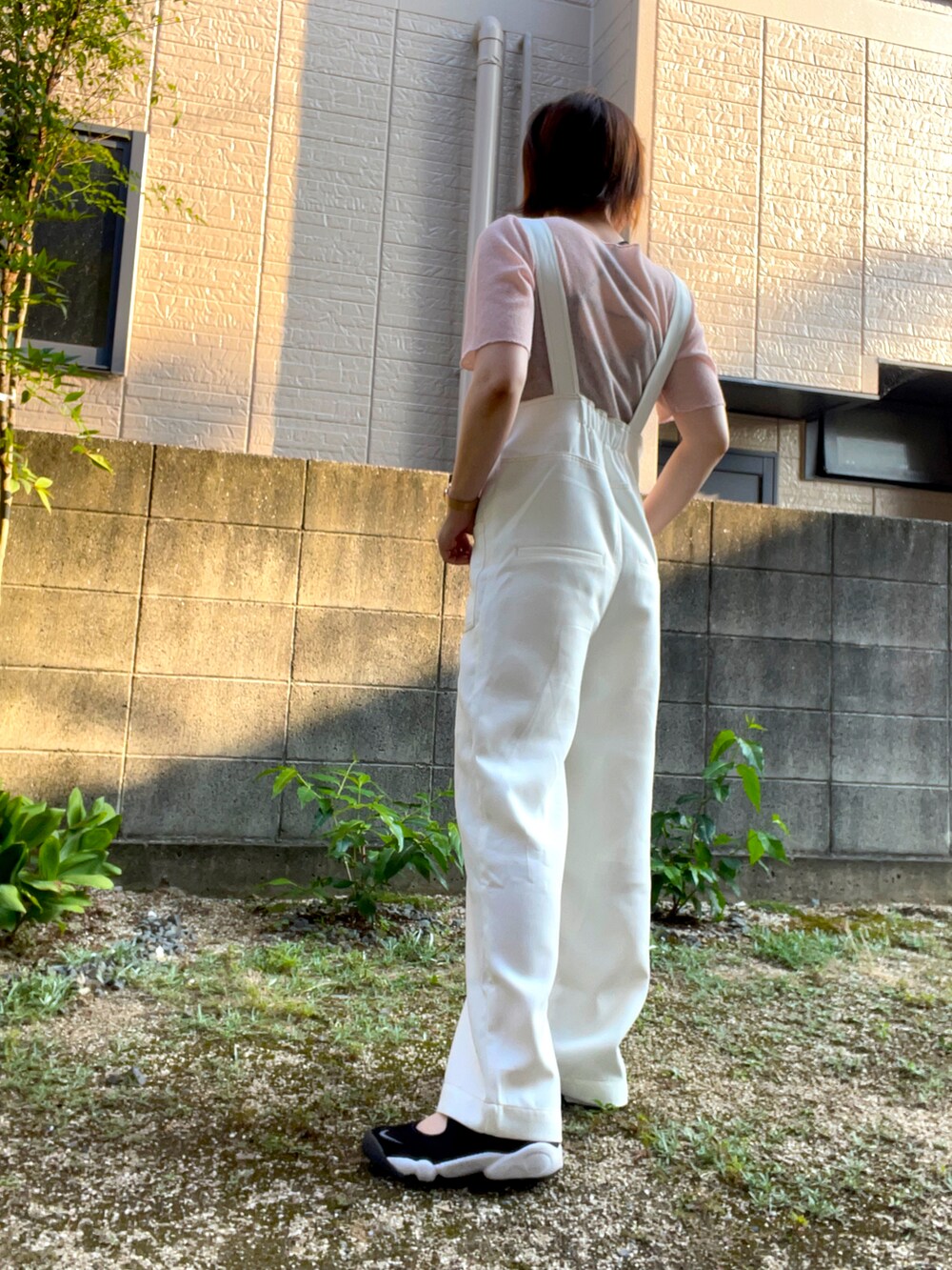 ホワイト系のサロペット/オーバーオール、ピンク系のTシャツ/カットソー、ブラック系のサンダルを着用したレディースの夏コーディネートの3枚目の写真