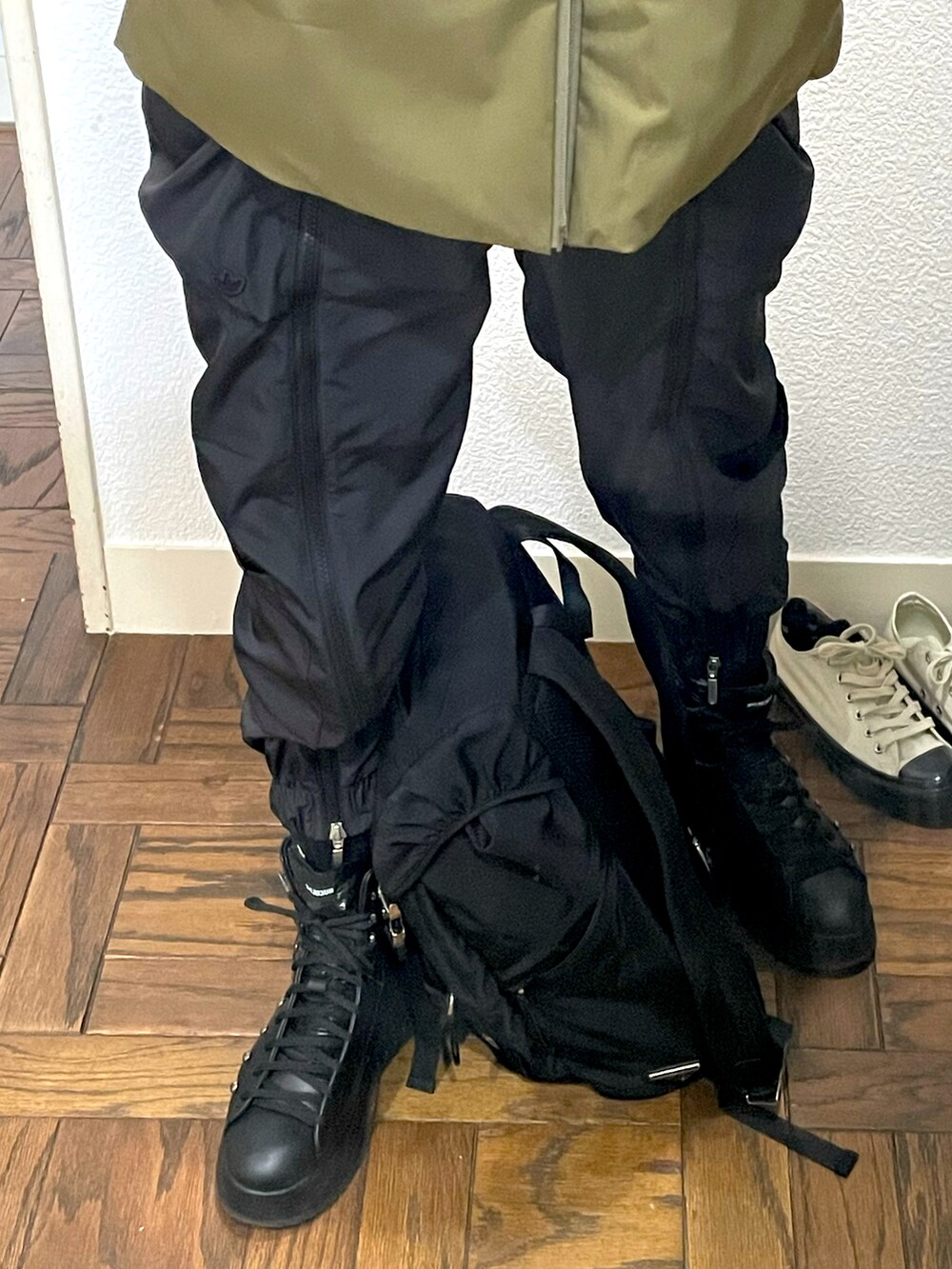 グリーン系のダウンジャケット/コート、ブラック系のパンツ、ブラック系のブーツを着用したレディースの冬コーディネートの3枚目の写真