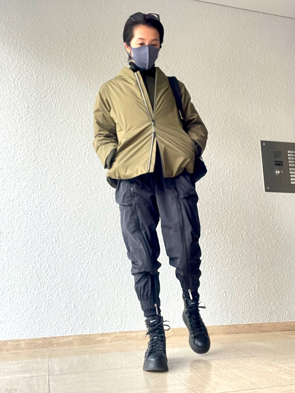 グリーン系のダウンジャケット/コート、ブラック系のパンツ、ブラック系のブーツを着用したレディースの冬コーディネートの2枚目の写真