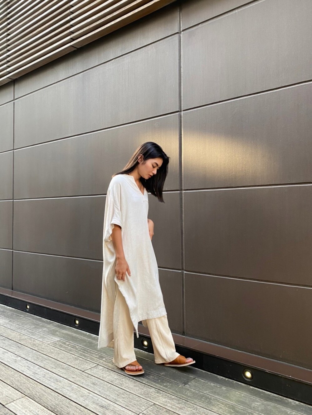 ベージュ系のワンピース、イエロー系のサンダルを着用したレディースの夏コーディネートの2枚目の写真