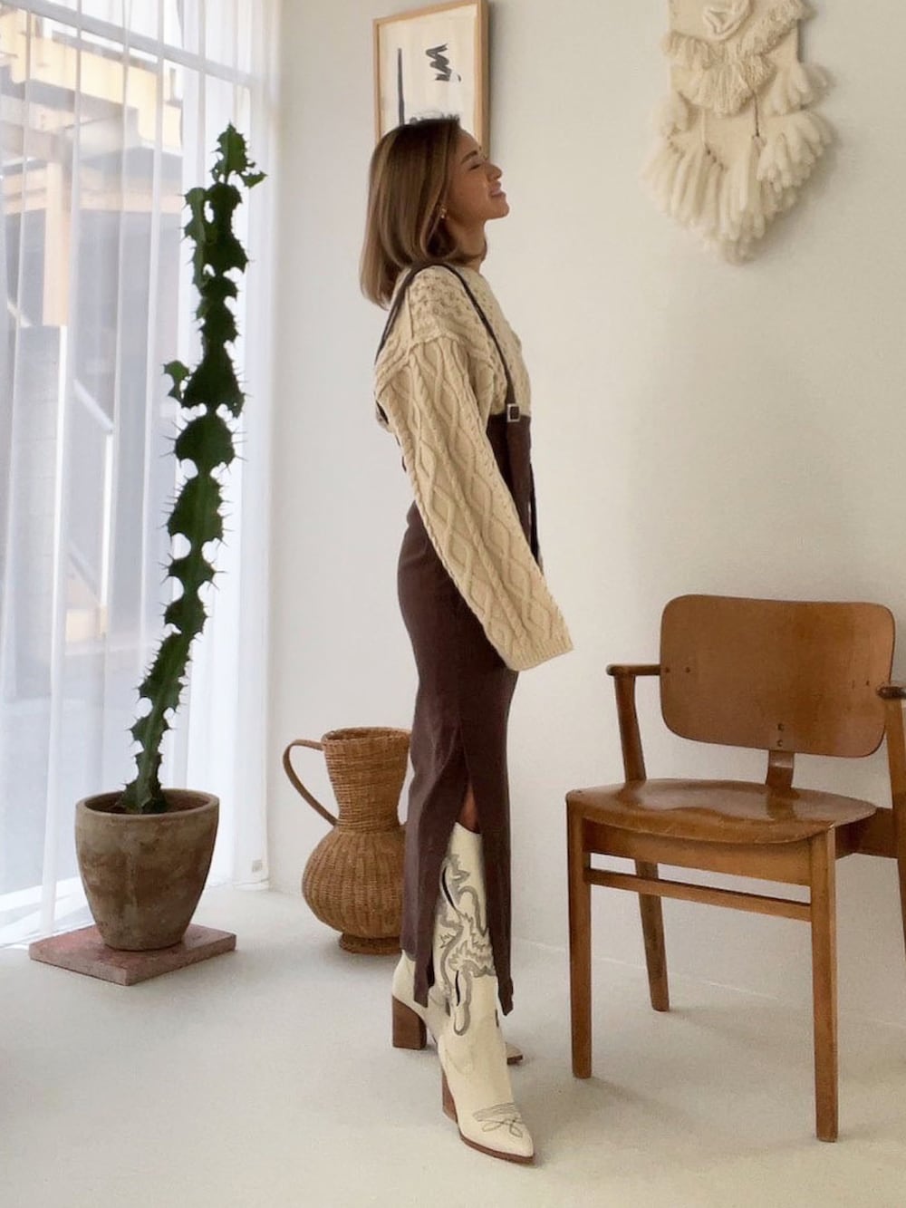 ホワイト系のニット/セーター、ブルー系のデニムパンツを着用したレディースの秋コーディネートの5枚目の写真