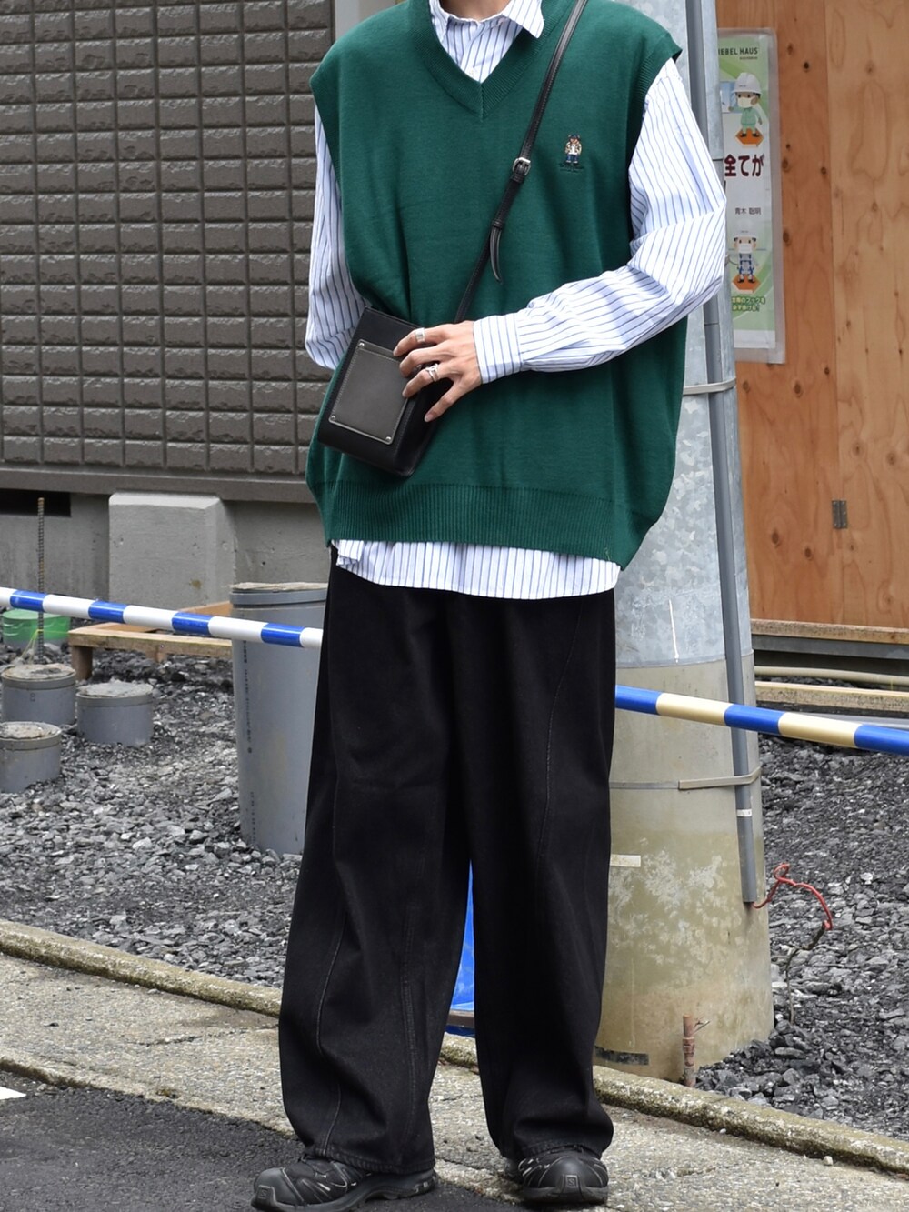 グリーン系のベスト、ホワイト系のシャツ/ブラウス、ブラック系のショルダーバッグを着用したメンズの秋コーディネートの2枚目の写真