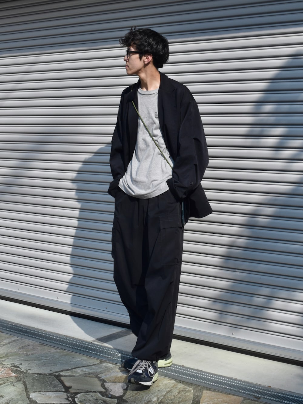 ブラック系のテーラードジャケット、ブラック系のカーゴパンツ、ブルー系のスニーカーを着用したメンズの秋コーディネートの2枚目の写真