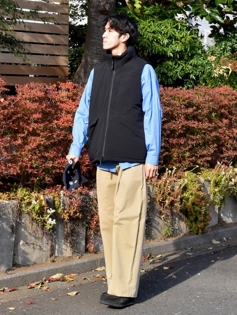ブラック系のベスト、ブルー系のシャツ/ブラウス、ベージュ系のチノパンツを着用したメンズの冬コーディネートの2枚目の写真