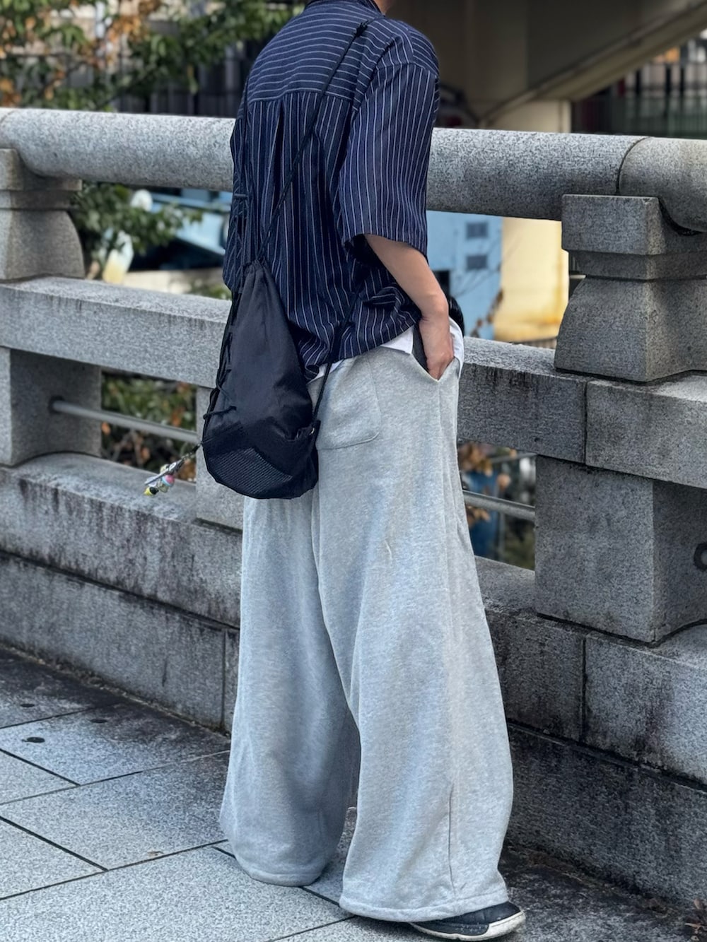 ブルー系のシャツ/ブラウス、グレー系のスウェットパンツ、ブラック系のスニーカーを着用したメンズの夏コーディネートの2枚目の写真