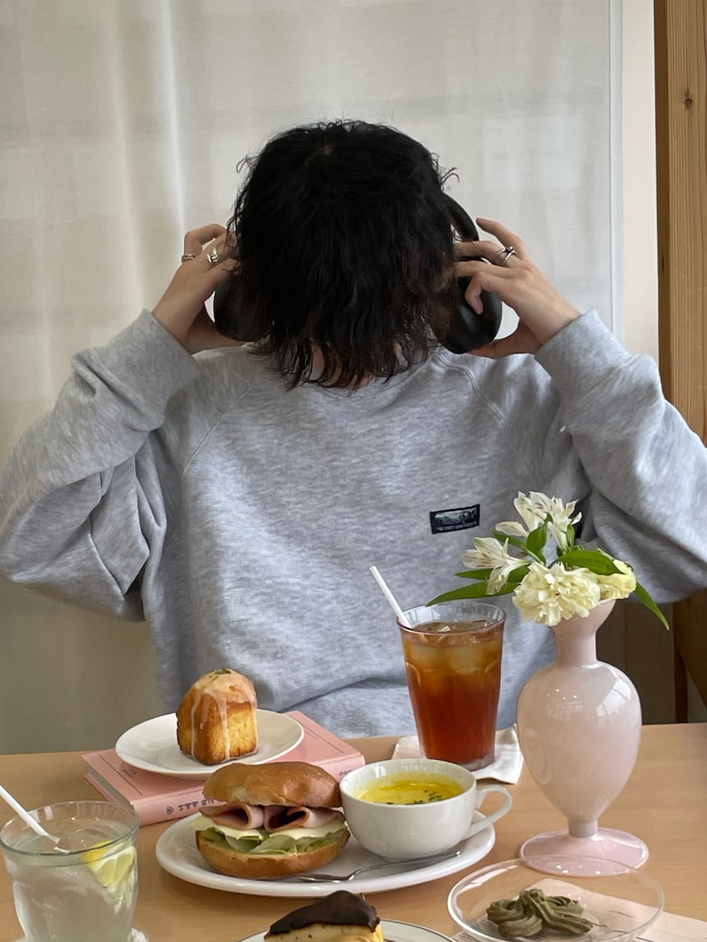 ブラック系のスラックス、ブラック系のスニーカー、ホワイト系のショルダーバッグを着用したメンズの春コーディネートの5枚目の写真