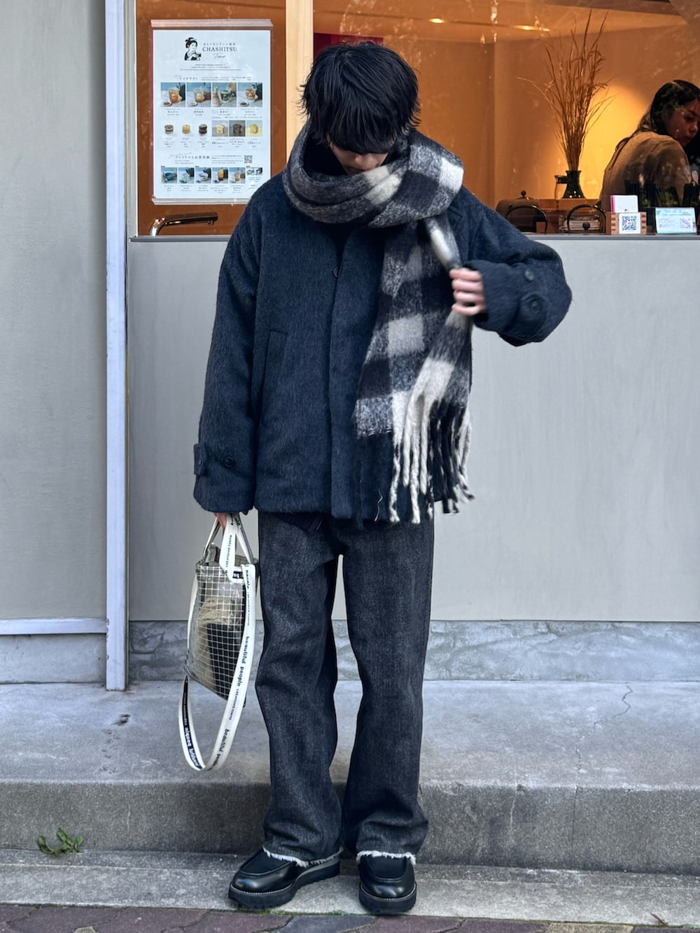 ブラック系のデニムパンツ、ブラック系のモカシン/デッキシューズ、ブラック系のブルゾンを着用したメンズの冬コーディネートの2枚目の写真