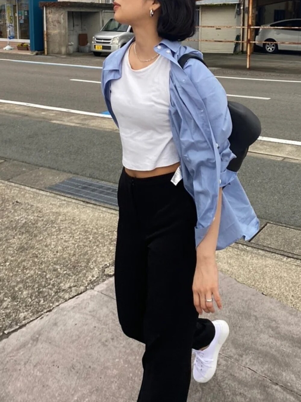 ホワイト系のTシャツ/カットソー、ブルー系のシャツ/ブラウス、ブラック系のスラックスを着用したレディースの夏コーディネートの3枚目の写真