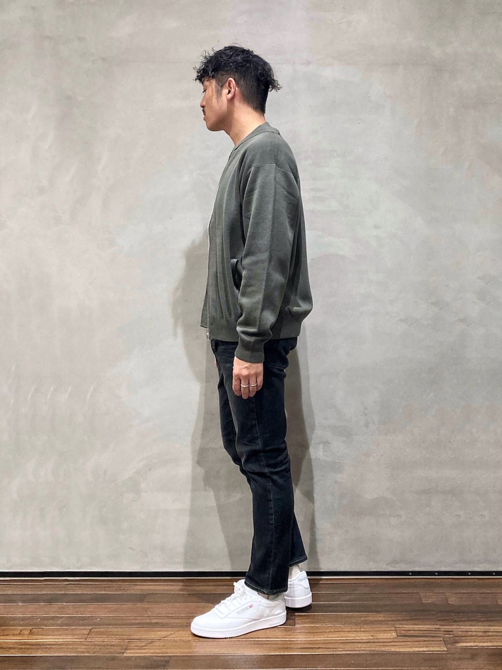 グリーン系のニット/セーターを着用したメンズの秋コーディネートの2枚目の写真