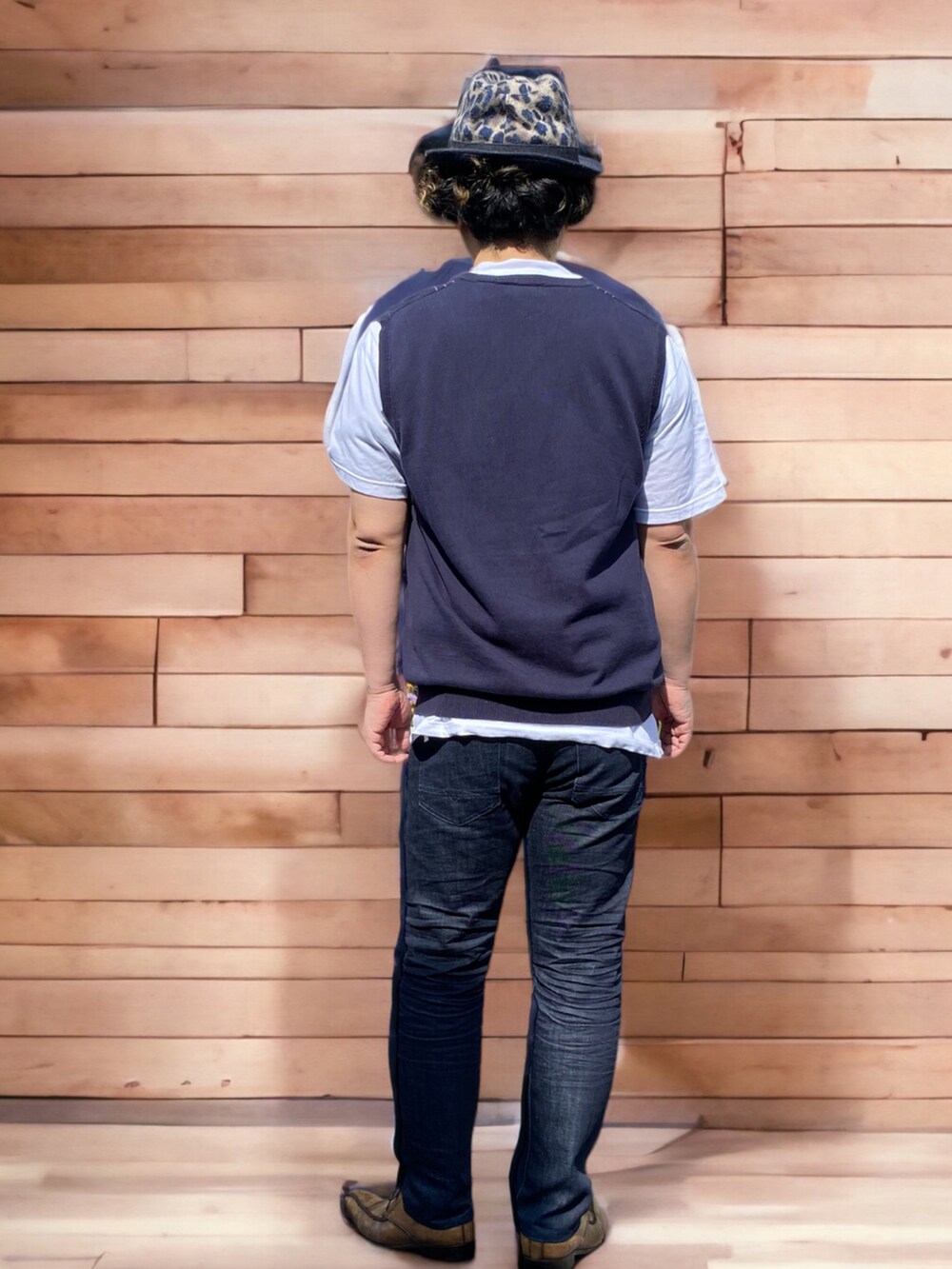 ブラック系のデニムパンツ、ブラウン系のドレスシューズ、ブルー系のベストを着用したメンズの春コーディネートの2枚目の写真