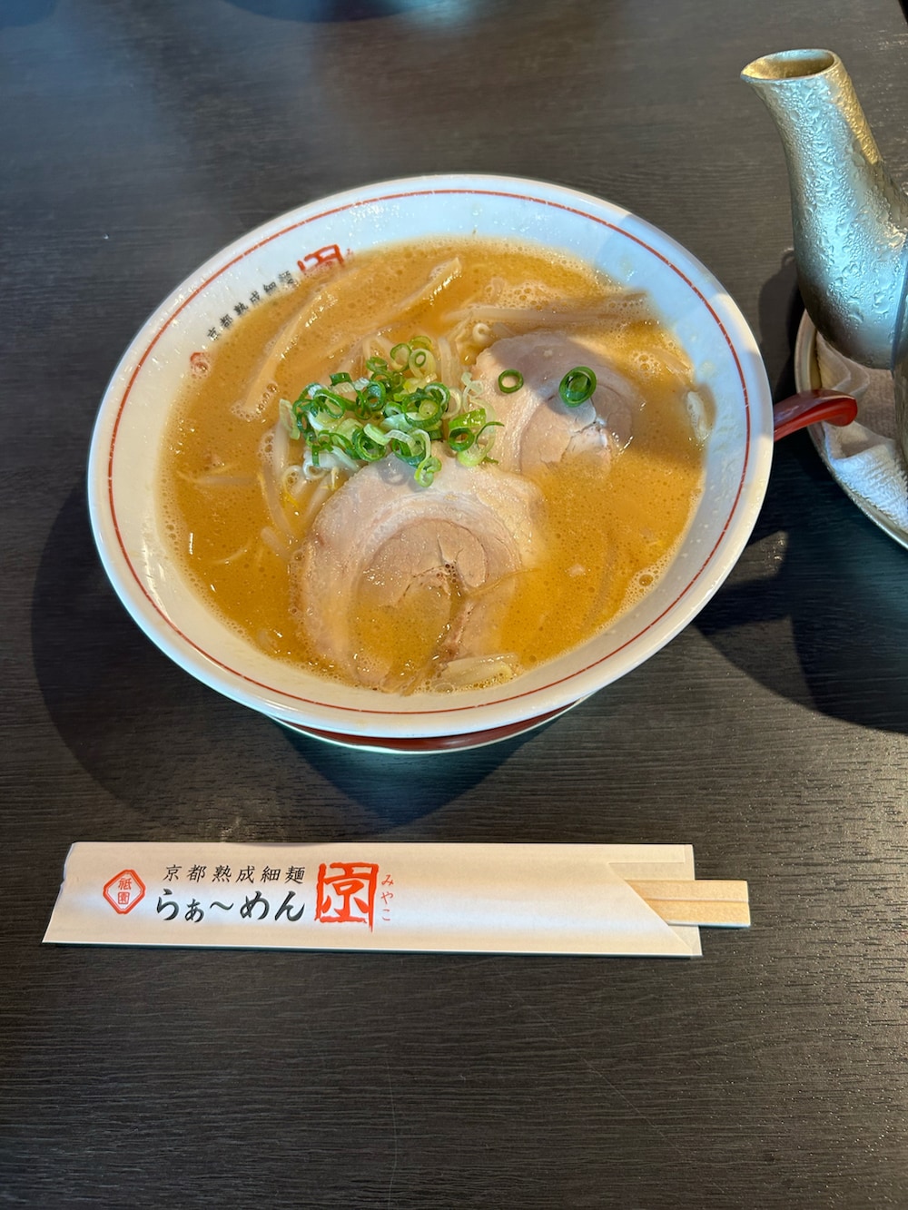 ホワイト系のTシャツ/カットソー、ブルー系のスラックス、ブラウン系の帽子を着用したメンズの秋コーディネートの2枚目の写真