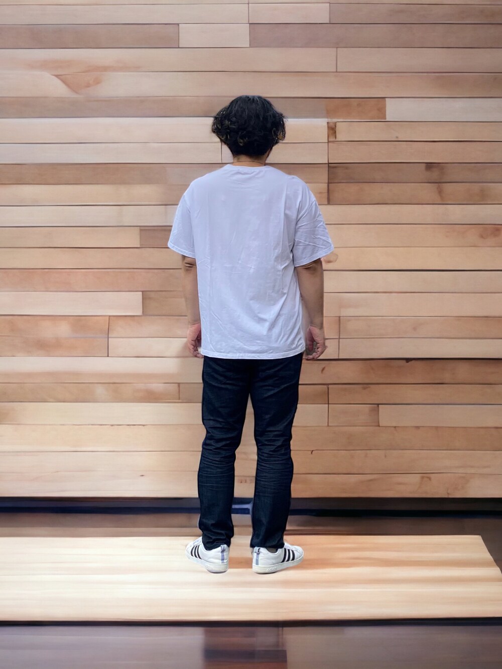 ブラック系のデニムパンツ、ホワイト系のスニーカー、ホワイト系のTシャツ/カットソーを着用したメンズの春コーディネートの2枚目の写真