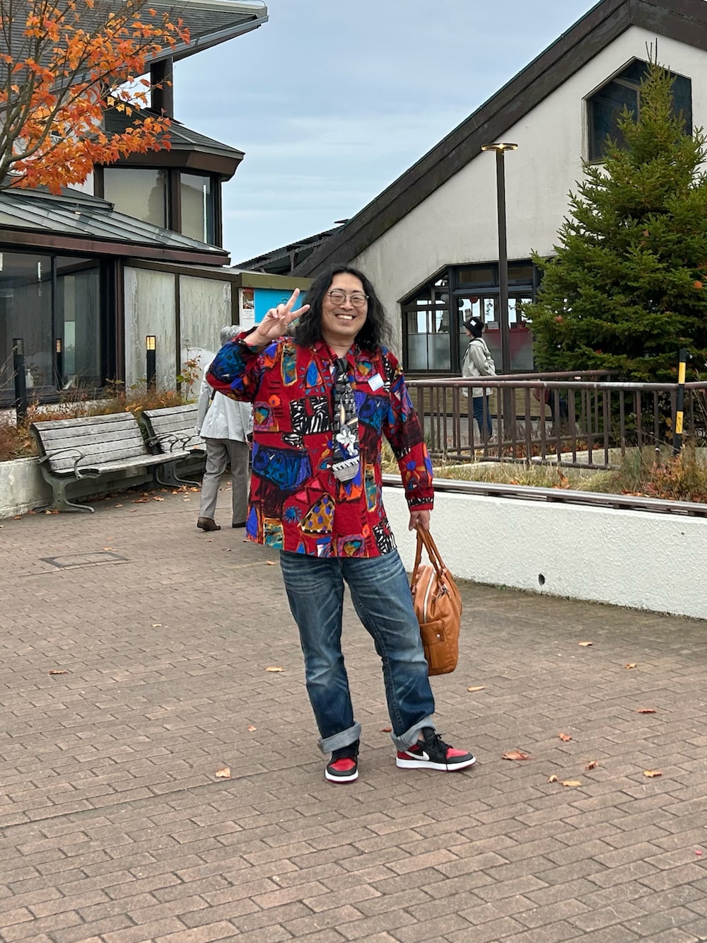 ブルー系のデニムパンツ、レッド系のスニーカー、レッド系のシャツ/ブラウスを着用したメンズの秋コーディネートの2枚目の写真