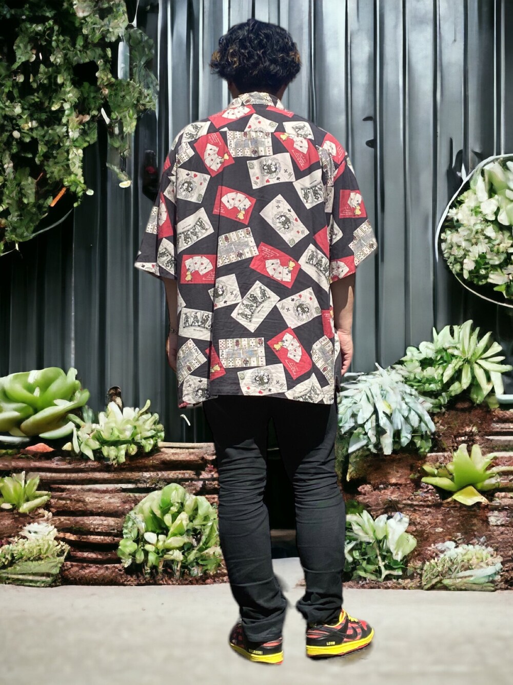 ブラック系のデニムパンツ、レッド系のスニーカー、ブラック系のシャツ/ブラウスを着用したメンズの春コーディネートの2枚目の写真