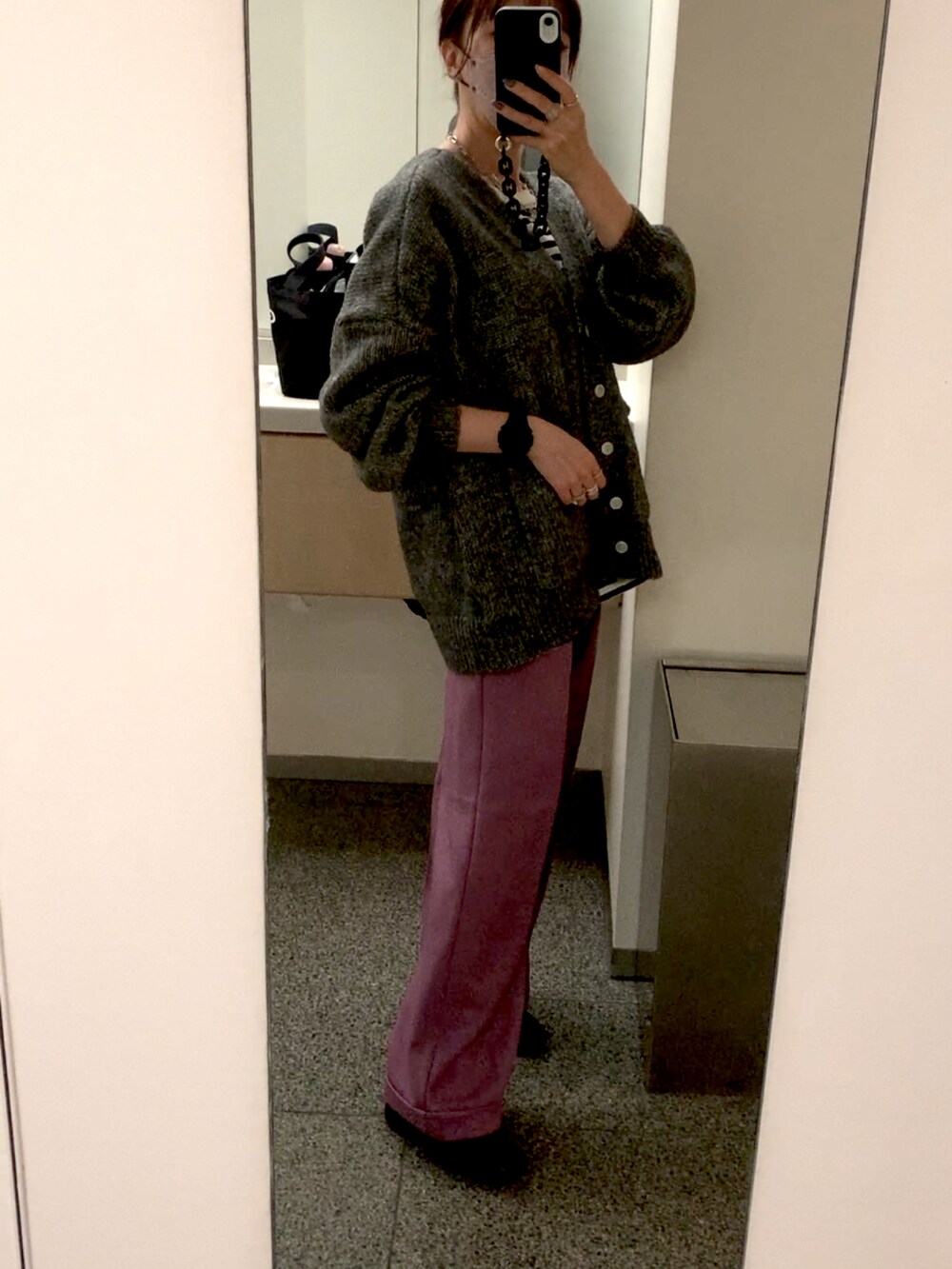 ホワイト系のダウンジャケット/コート、グレー系のカーディガン/ボレロ、パープル系のスラックスを着用したレディースの冬コーディネートの2枚目の写真