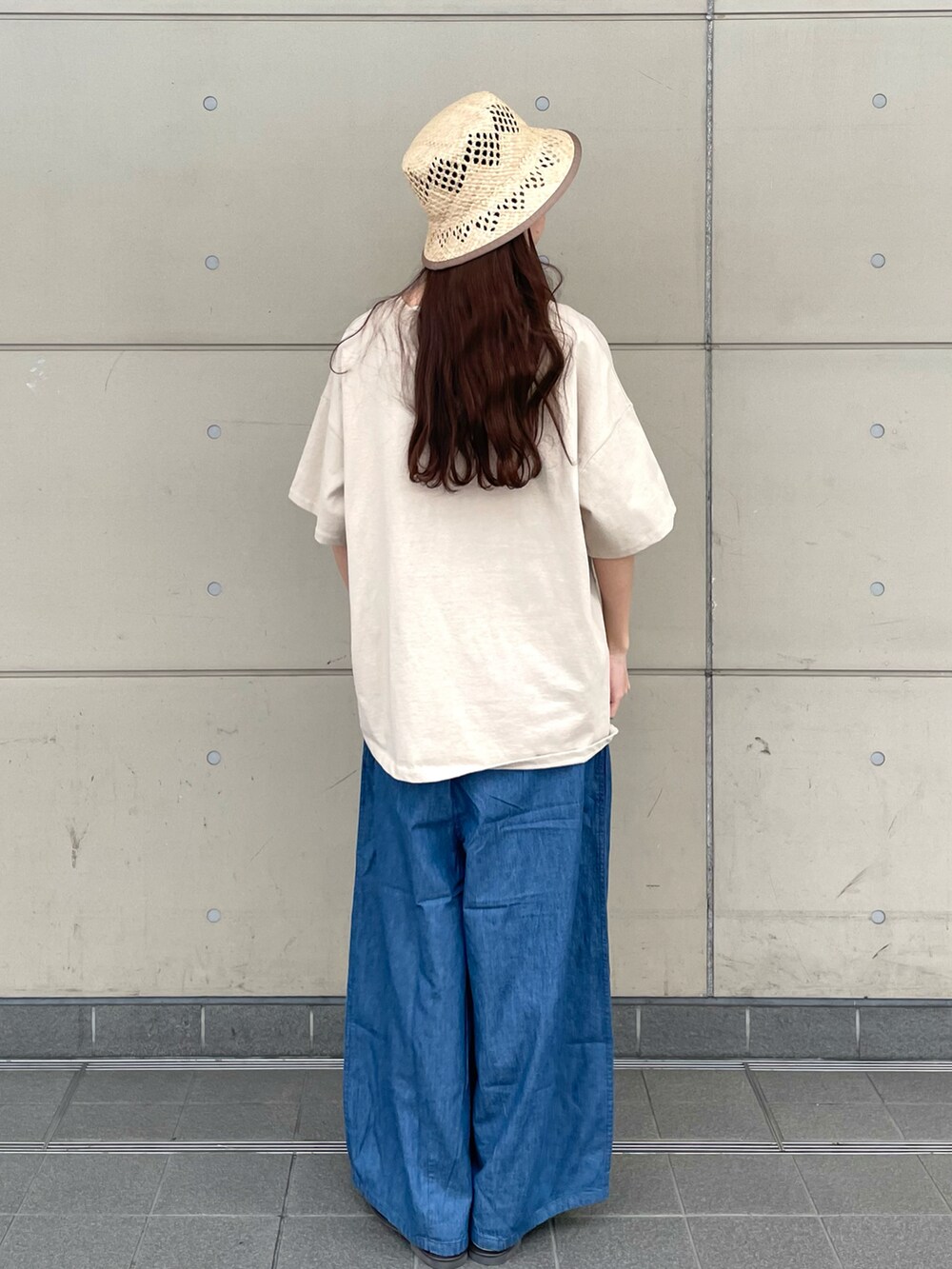 ベージュ系のTシャツ/カットソー、ベージュ系のタンクトップ、ブルー系のパンツを着用したレディースの春コーディネートの2枚目の写真