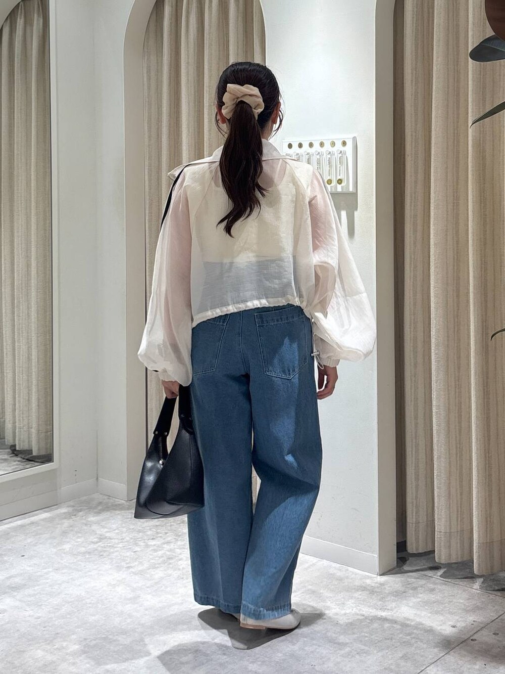 ホワイト系のタンクトップ、シルバー系のバレエシューズ、ベージュ系のブルゾンを着用したレディースの春コーディネートの3枚目の写真