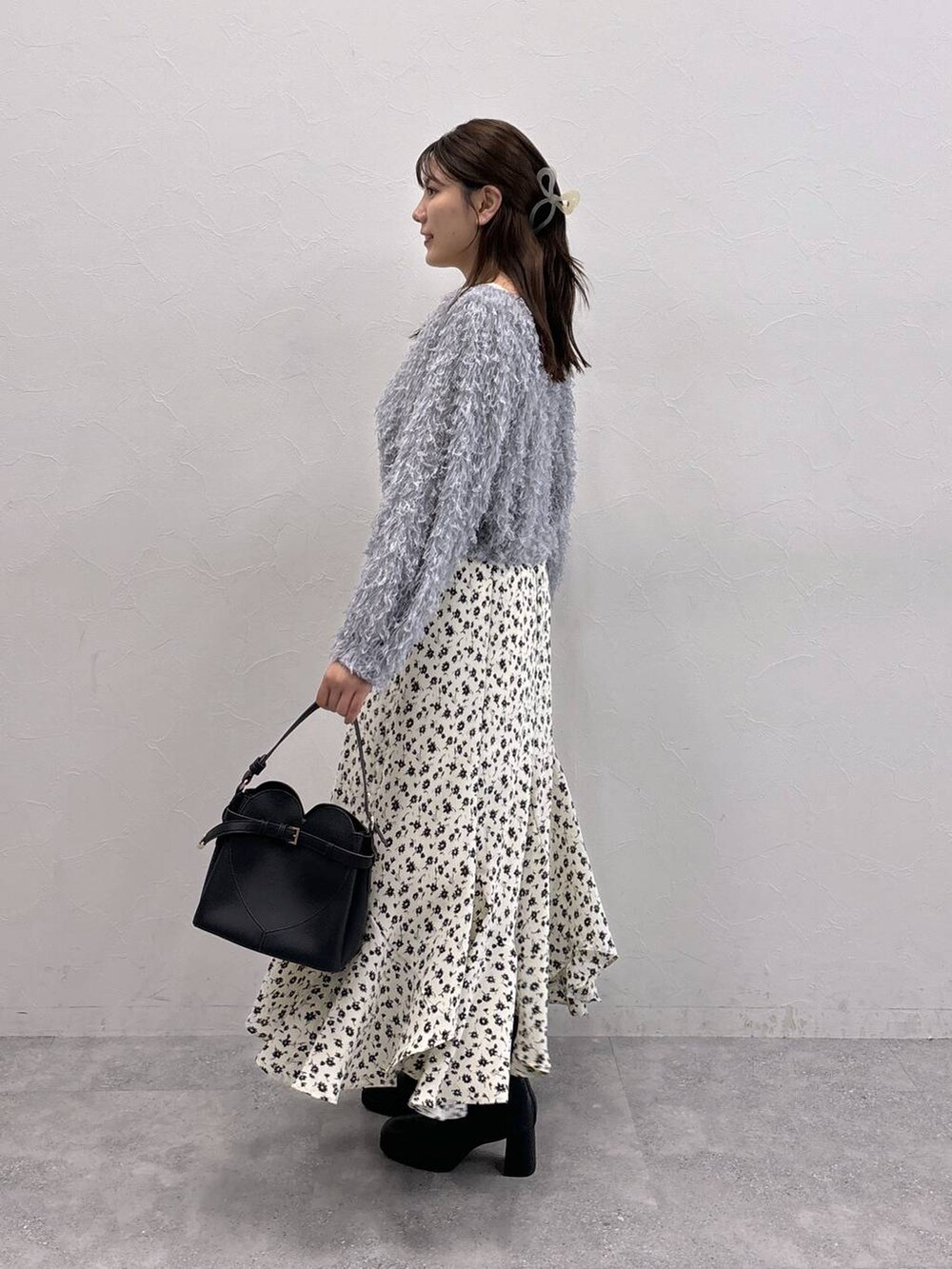 ブラック系のショルダーバッグ、ホワイト系のスカート、ホワイト系のTシャツ/カットソーを着用したレディースの秋コーディネートの2枚目の写真