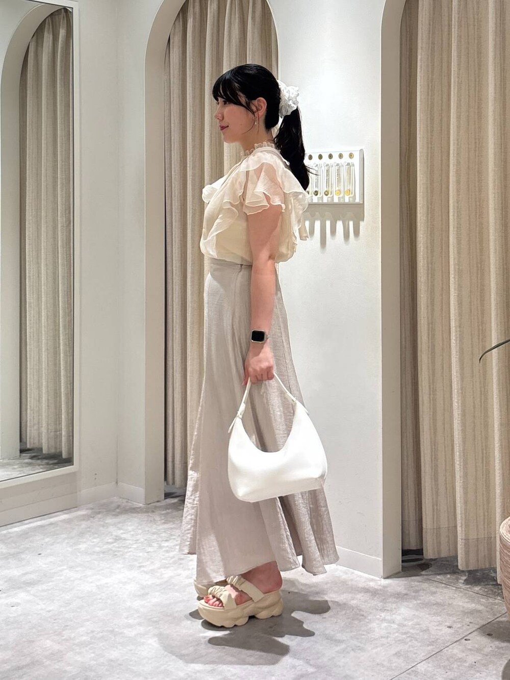 ホワイト系のサンダル、ホワイト系のショルダーバッグ、ホワイト系のシャツ/ブラウスを着用したレディースの春コーディネートの2枚目の写真
