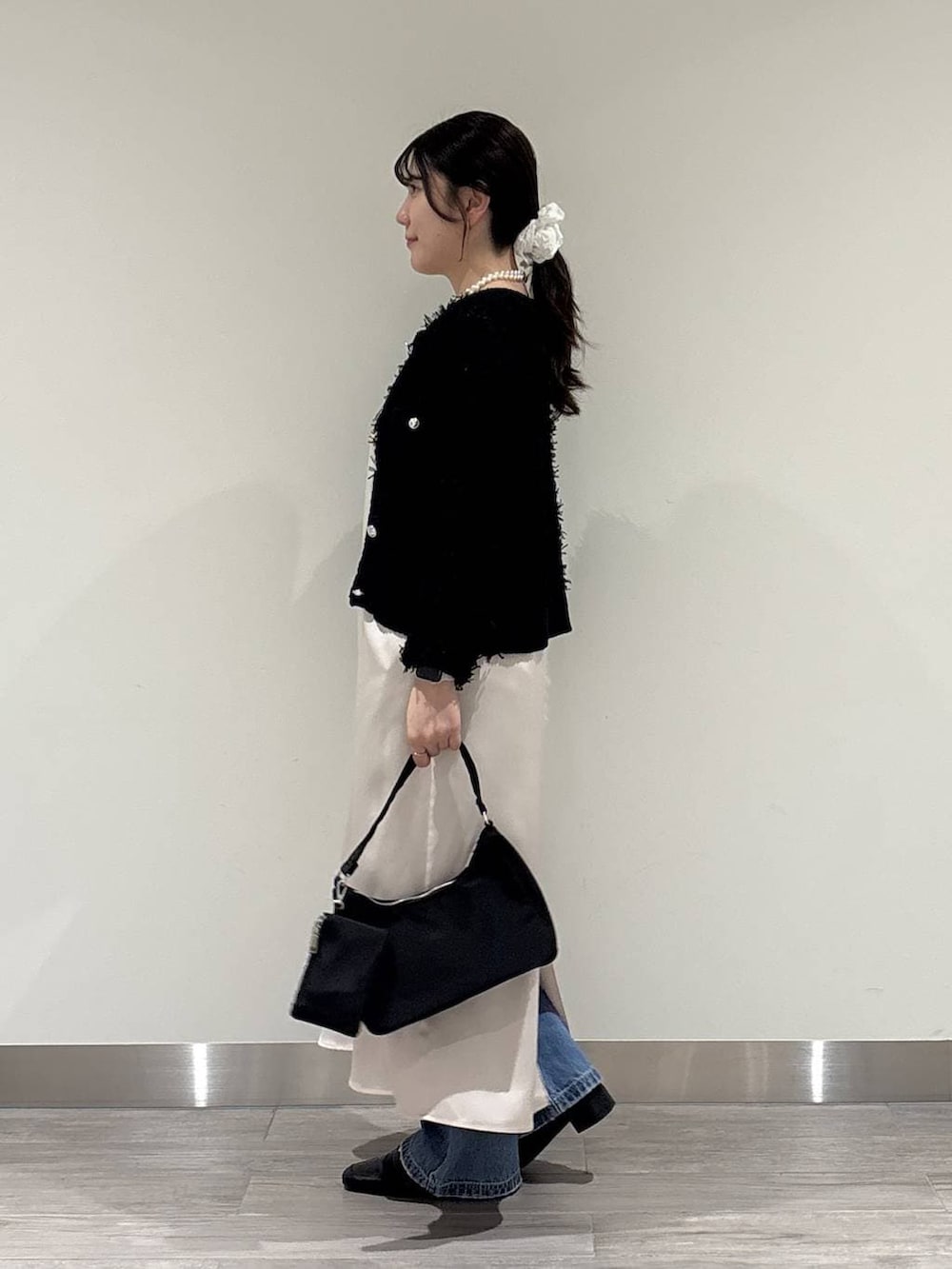 ブラック系のローファー、ブラック系のハンドバッグ、ブラック系のカーディガン/ボレロを着用したレディースの冬コーディネートの2枚目の写真